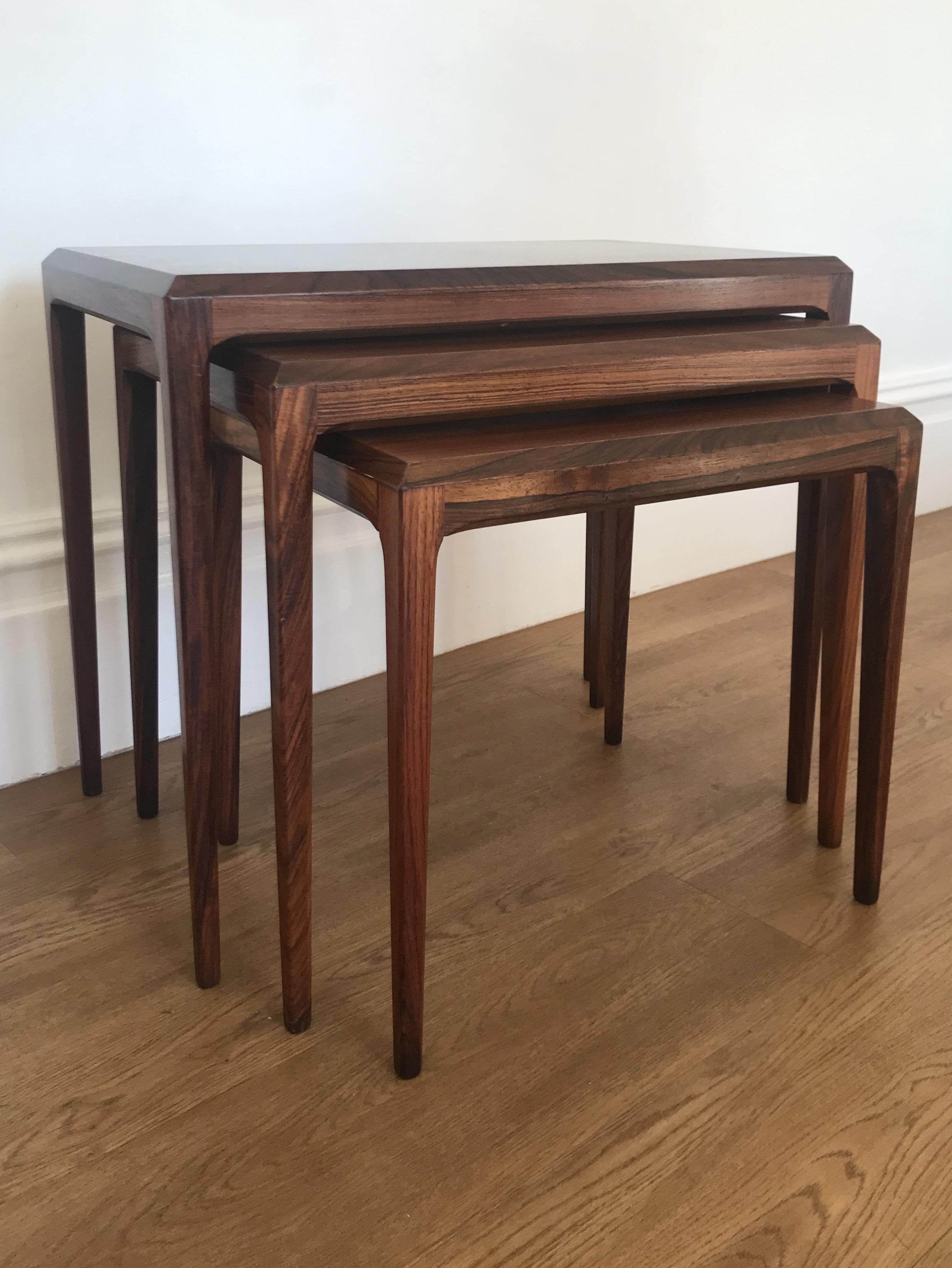 Set of 3 superbly designed rosewood tables designed by Johannes Andersen for CFC Silkeborg, Denmark.

The tables feature tapered octagonal legs with chamfered tops and a lovely rosewood grain running throughout.

The tables are in very good