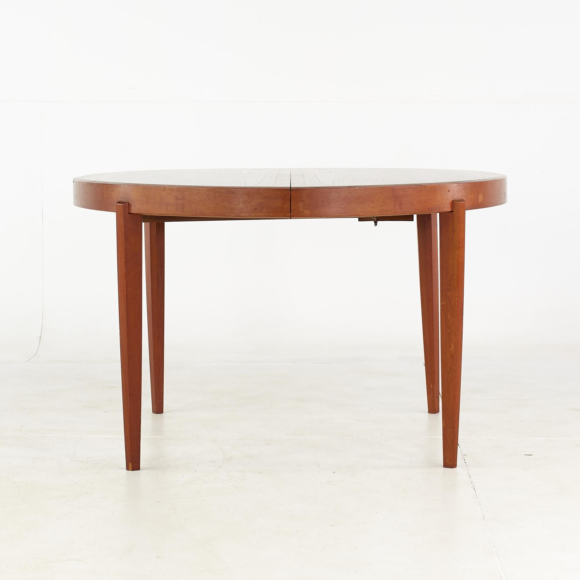 Johannes Andersen style mid-century teak expanding dining table with 4 leaves.

This table measures: 47.25 wide x 47.25 deep x 29 high, with a chair clearance of 26.5 inches, each leaf measures 21.75 inches wide, making a maximum table width of
