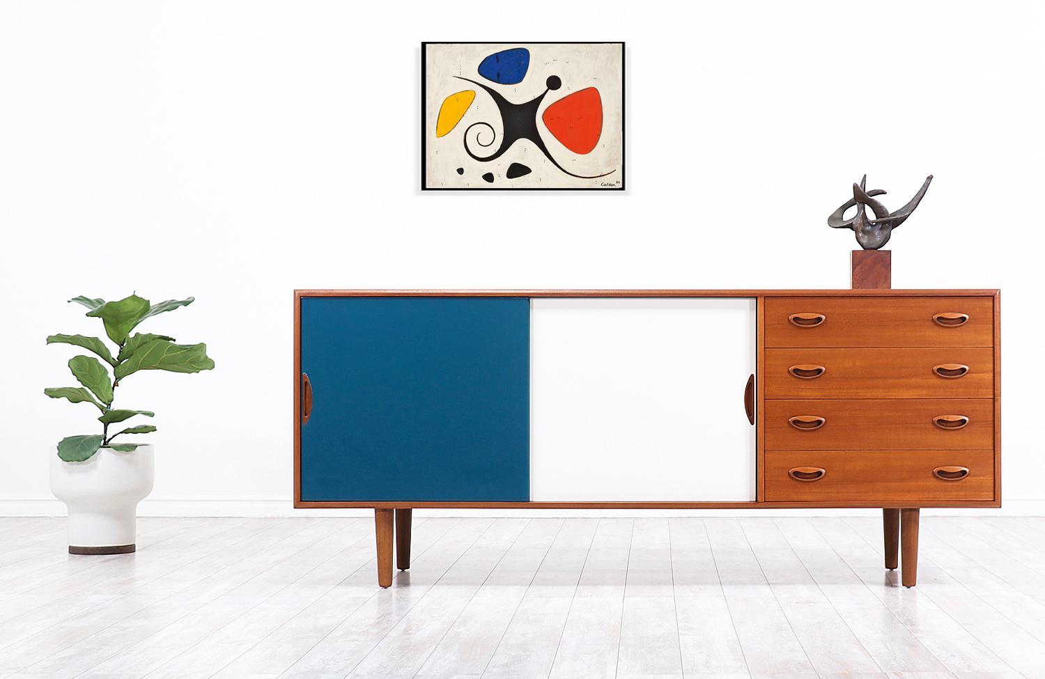 Stylish modern credenza by iconic Danish designer Johannes Andersen for Georg Pedersens in Denmark circa 1950s. This skillfully crafted credenza features a sturdy teak case with a stunning high polished, glossy finish in ivory white and teal blue on