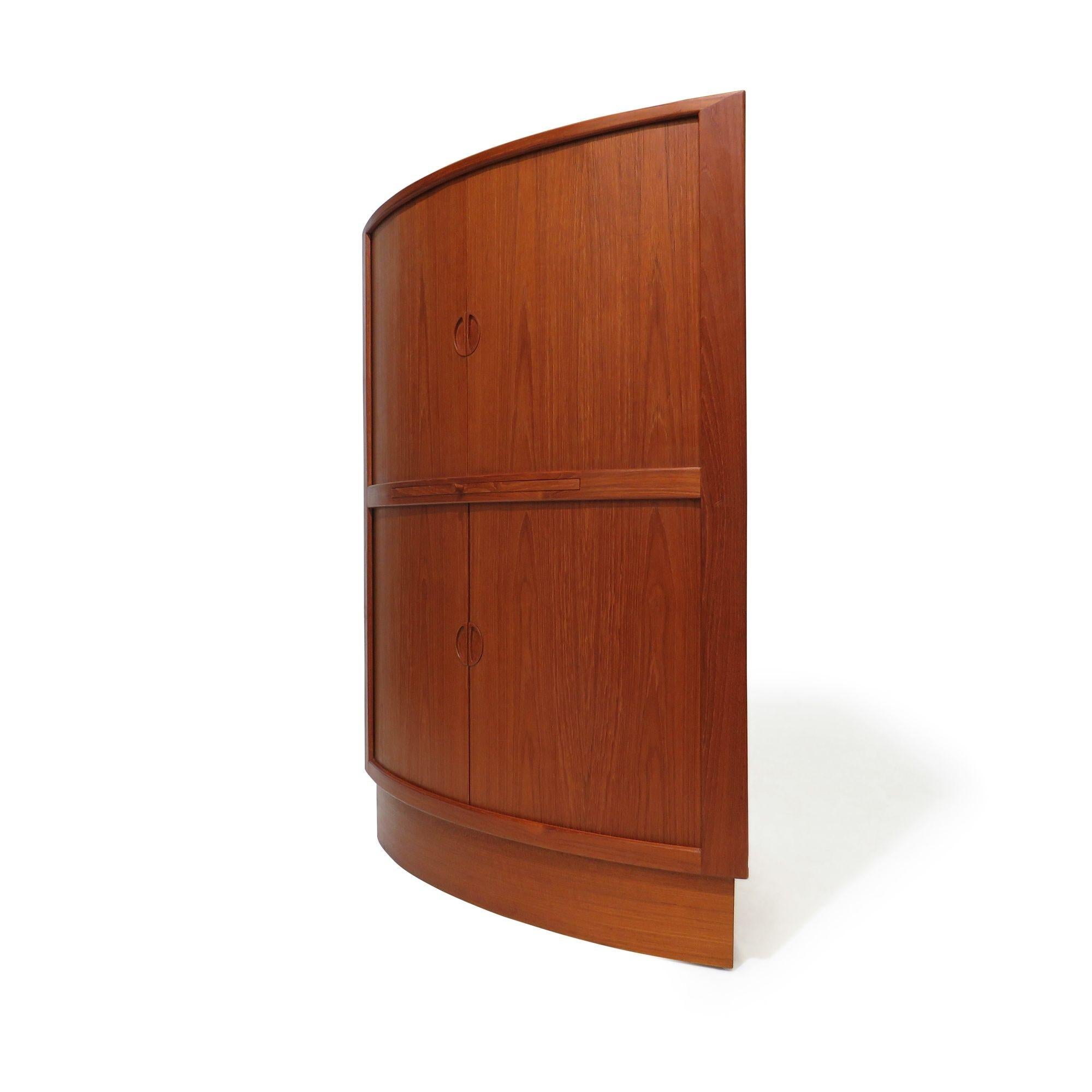 Mid-century Danish teak corner cabinet with stunning tambour doors and carved pulls designed by Arne Johannes Andersen,1955, Denmark. The tambour doors open to reveal an interior of teak. The upper section has one adjustable shelf and two felt-lined