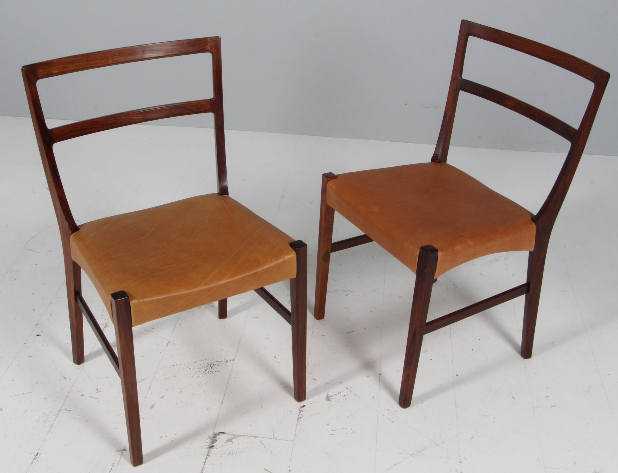 Johannes Andersen two dining chairs in solid oiled rosewood.

New upholstered with vintage tan aniline leather.

Made by Bernhard Pedersen & Søn.