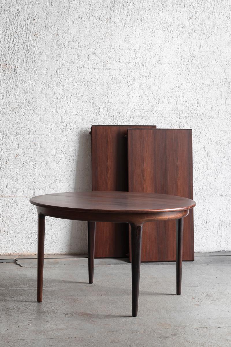 Cette table de salle à manger extensible a été conçue par Johannes Andersen et produite par Uldum Møbelfabrik au Danemark dans les années 1960. Elle peut être placée comme une table ronde, pouvant accueillir 4 personnes, ou vous pouvez l'allonger