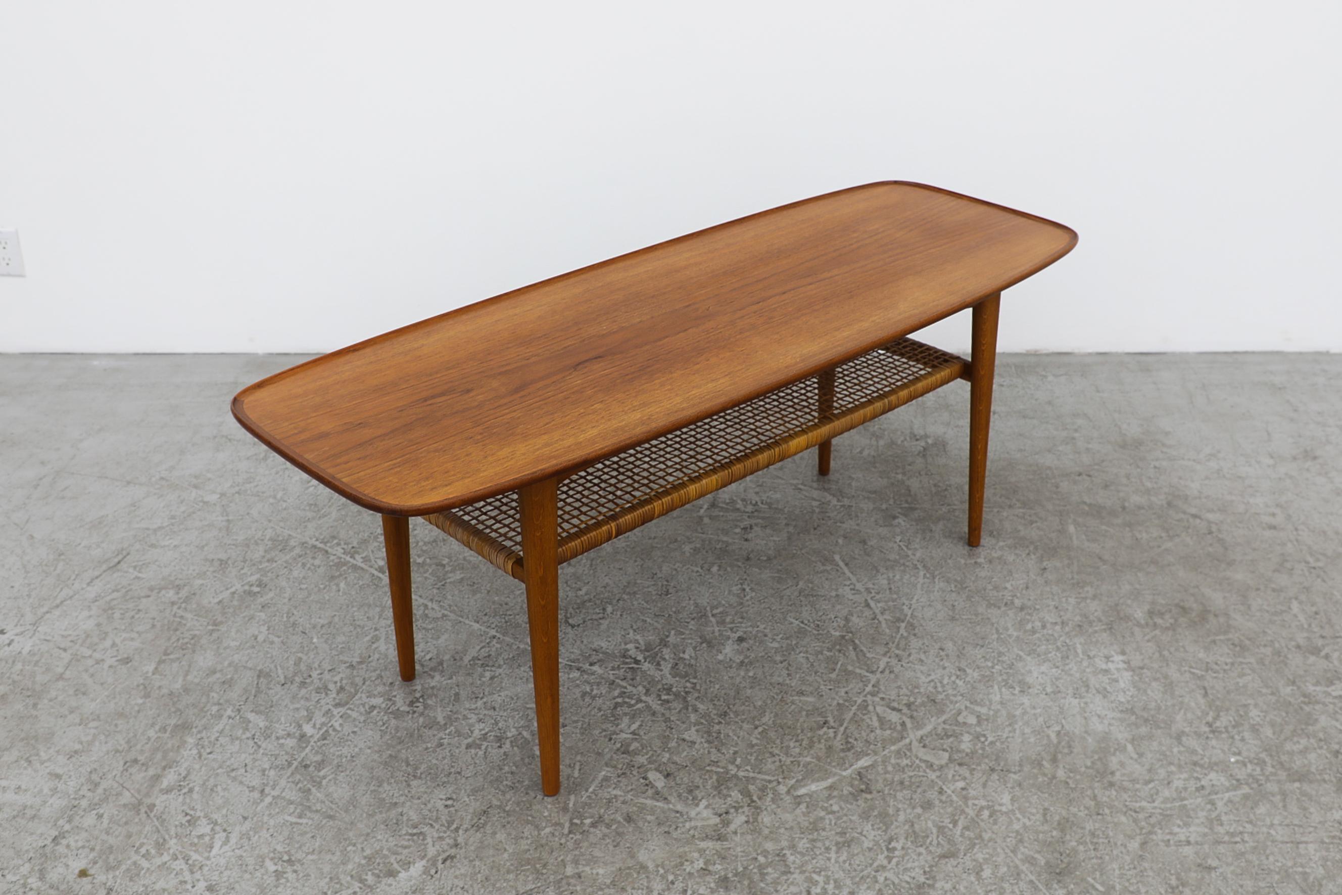 Johannes Anderson Rounded Danish Teak Coffee Table w/ Lip & Lower Rattan Shelf In Good Condition For Sale In Los Angeles, CA