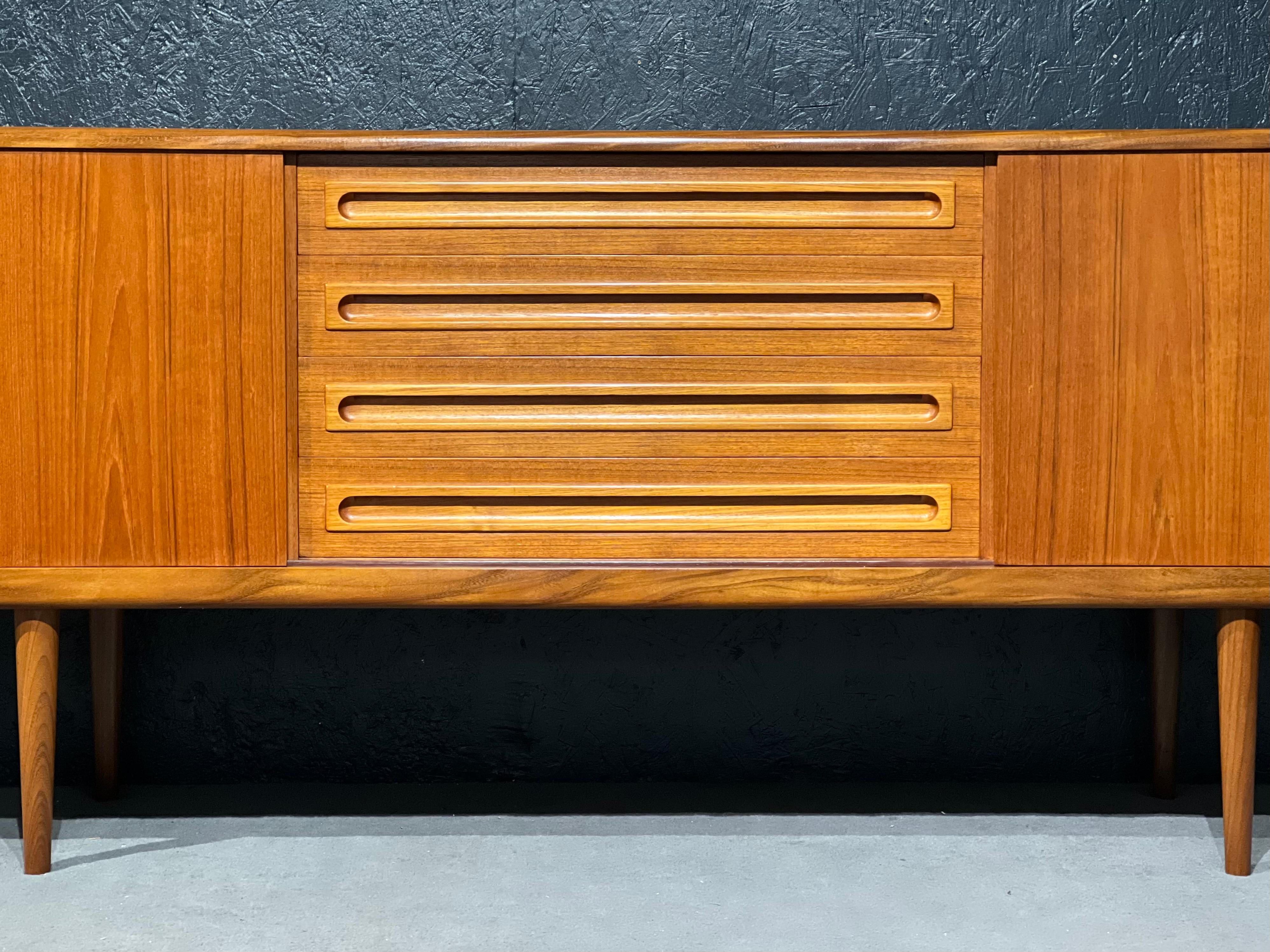 The sideboard design is featured by symmetry, with a bank of 4 drawers n the center and two cupboards enclosed by sliding doors on each side. All were designed and handcrafted with the mastery of the Danish cabinetmakers of the time. 
Johannes