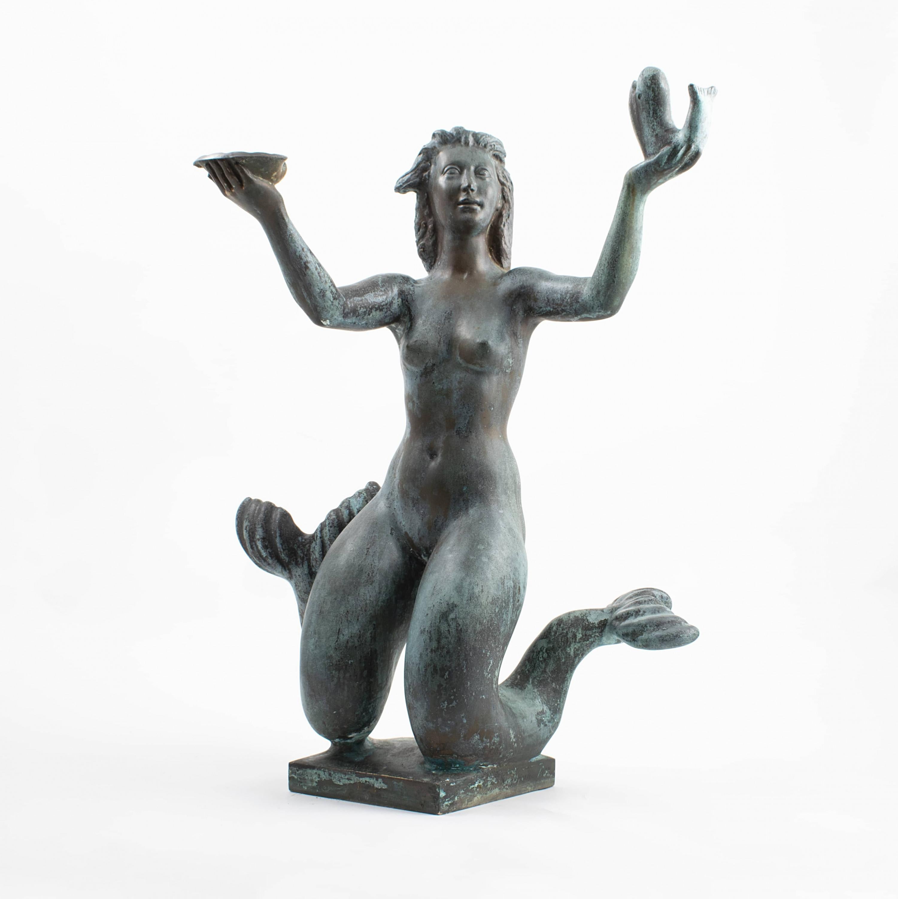 Johannes C. Bjerg, 1886-1955.
Bronze sculpture in the form of mermaid fountain with fish and mussel. The water springs from the fish's mouth to the mussel. Mounted on original granite base, with natural organic shape. Beautiful natural,
