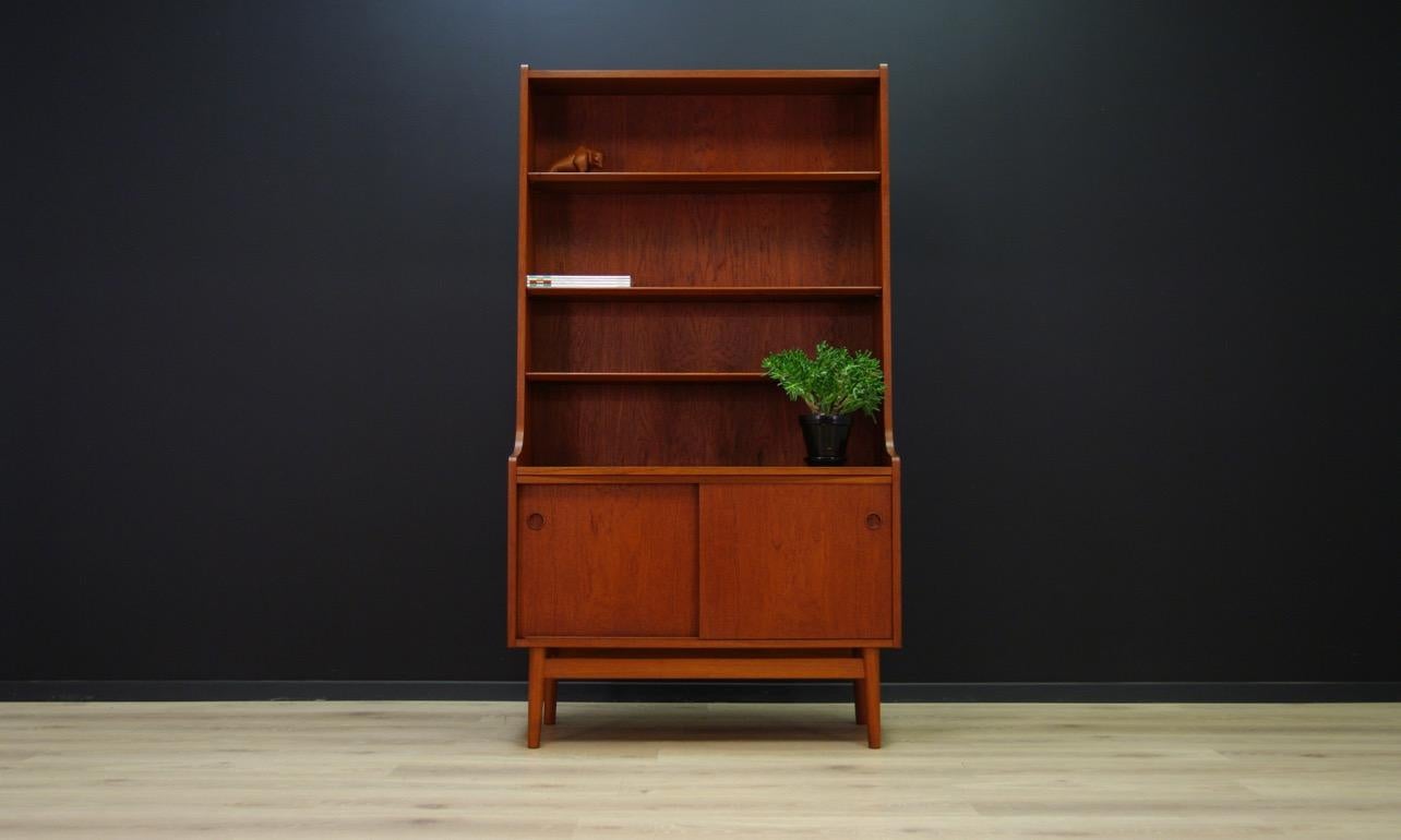 Unique bookcase from the 1960s-1970s, minimalist form designed by Johannes Sorth. Numerous shelves and ample storage space with a shelf behind sliding doors. Bookcase veneered with teak. Preserved in good condition (small dings and scratches, darker
