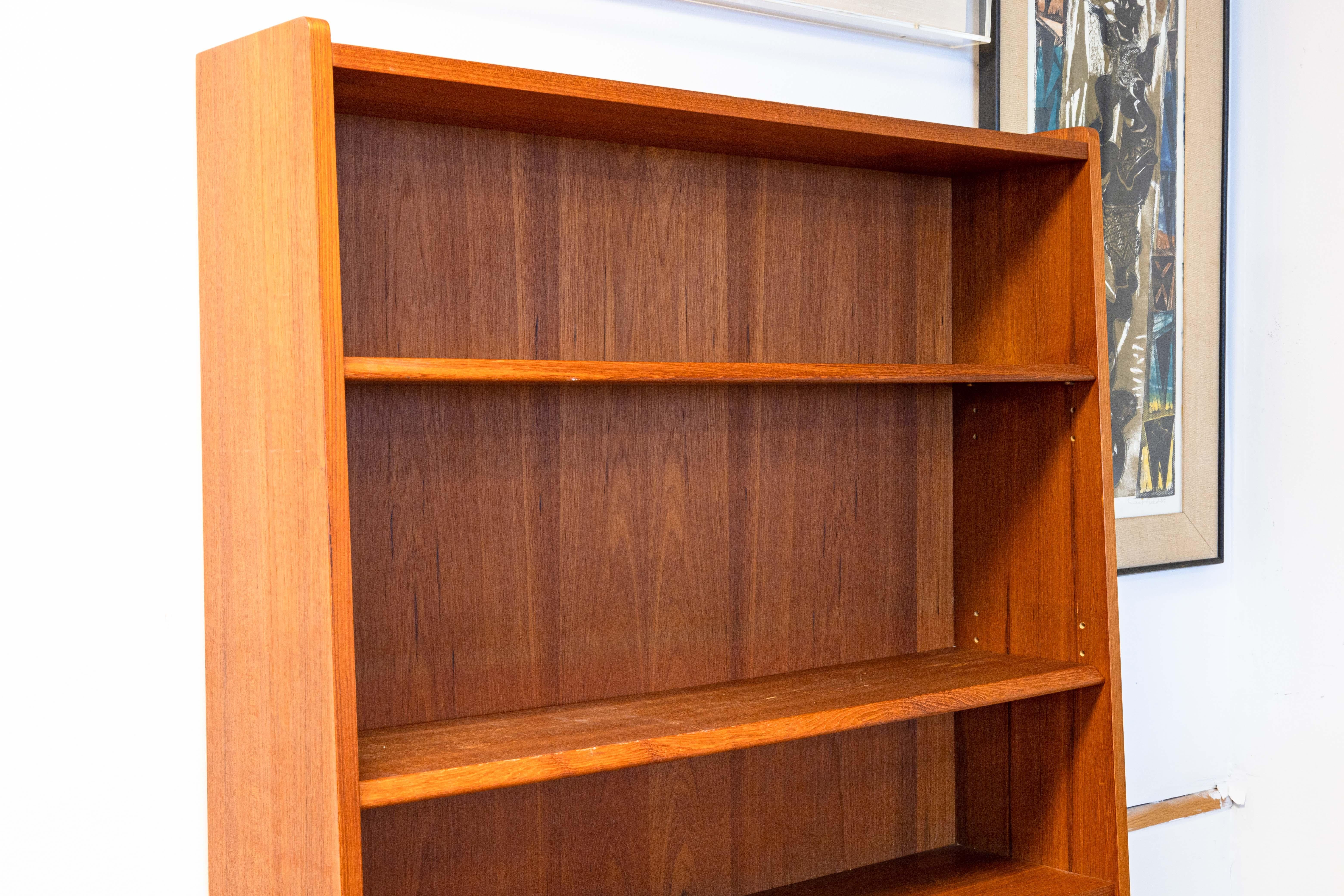 A Johannes Sorth for Nexø Møbelfabrik bookshelf secretary. This lovely Danish mid century modern piece features a full teak wood construction. The color and grain of the unit looks beautiful and is in very good vintage condition. The top of this