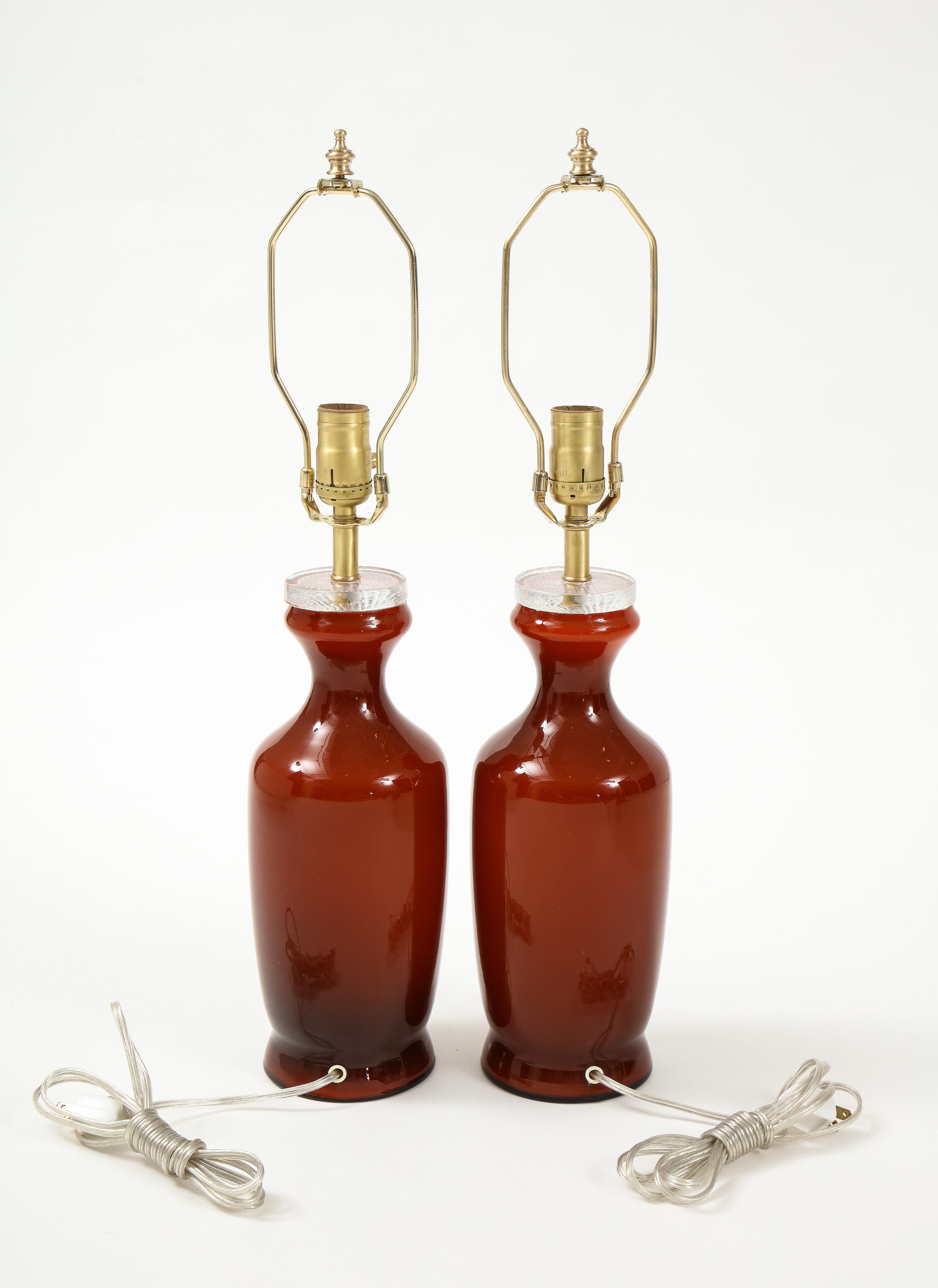 Pair of Scandinavian Modern glass lamps in a wonderful burnt orange/red color with brass fittings. 100W max bulbs. Rewired for use in USA.