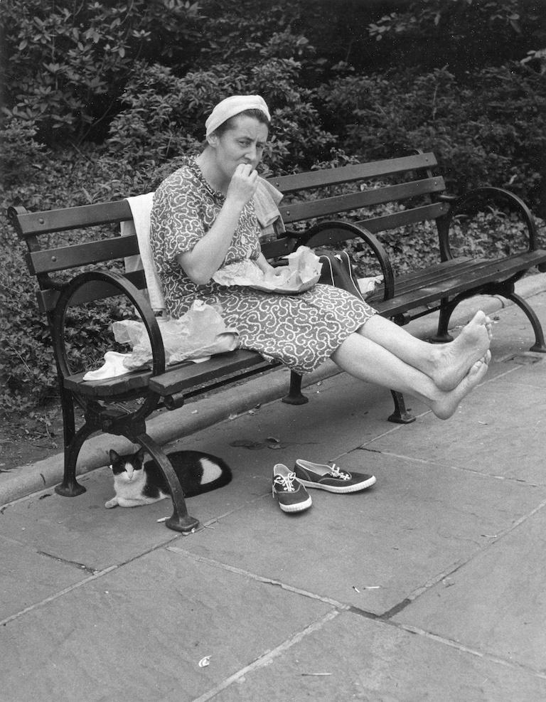 John Albok Black and White Photograph – Ohne Titel (Barefoot Woman on Bench with Cat)