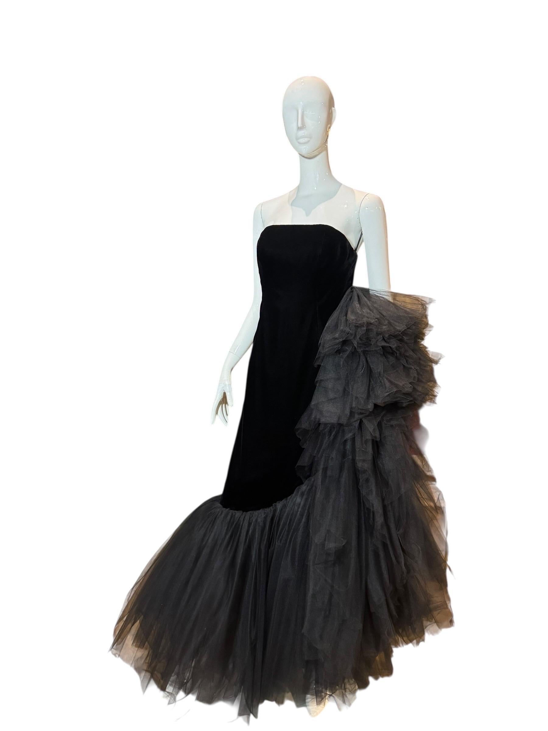 Création couture unique et époustouflante du designer américain John Anthony, cette robe de soirée des années 1980 incarne le summum du glamour sur tapis rouge. Confectionnée dans un somptueux velours noir de jais, la silhouette colonne sans
