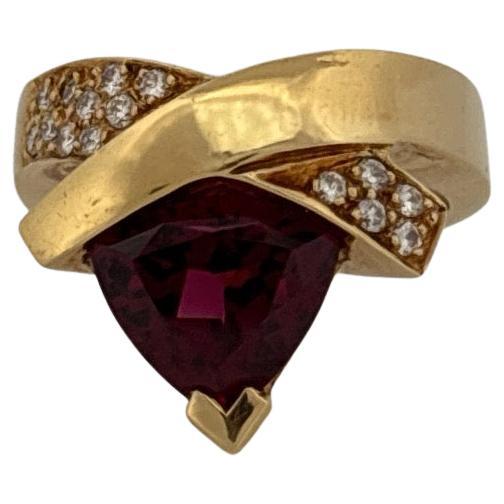 Dieser auffällige Ring von John Atencio ist ein kühner Ausdruck von moderner Kunst und feiner Handwerkskunst. Das aus luxuriösem 18-karätigem Gelbgold gefertigte Design besticht durch einen 3,4 Karat schweren Granat im Billionenschliff, dessen