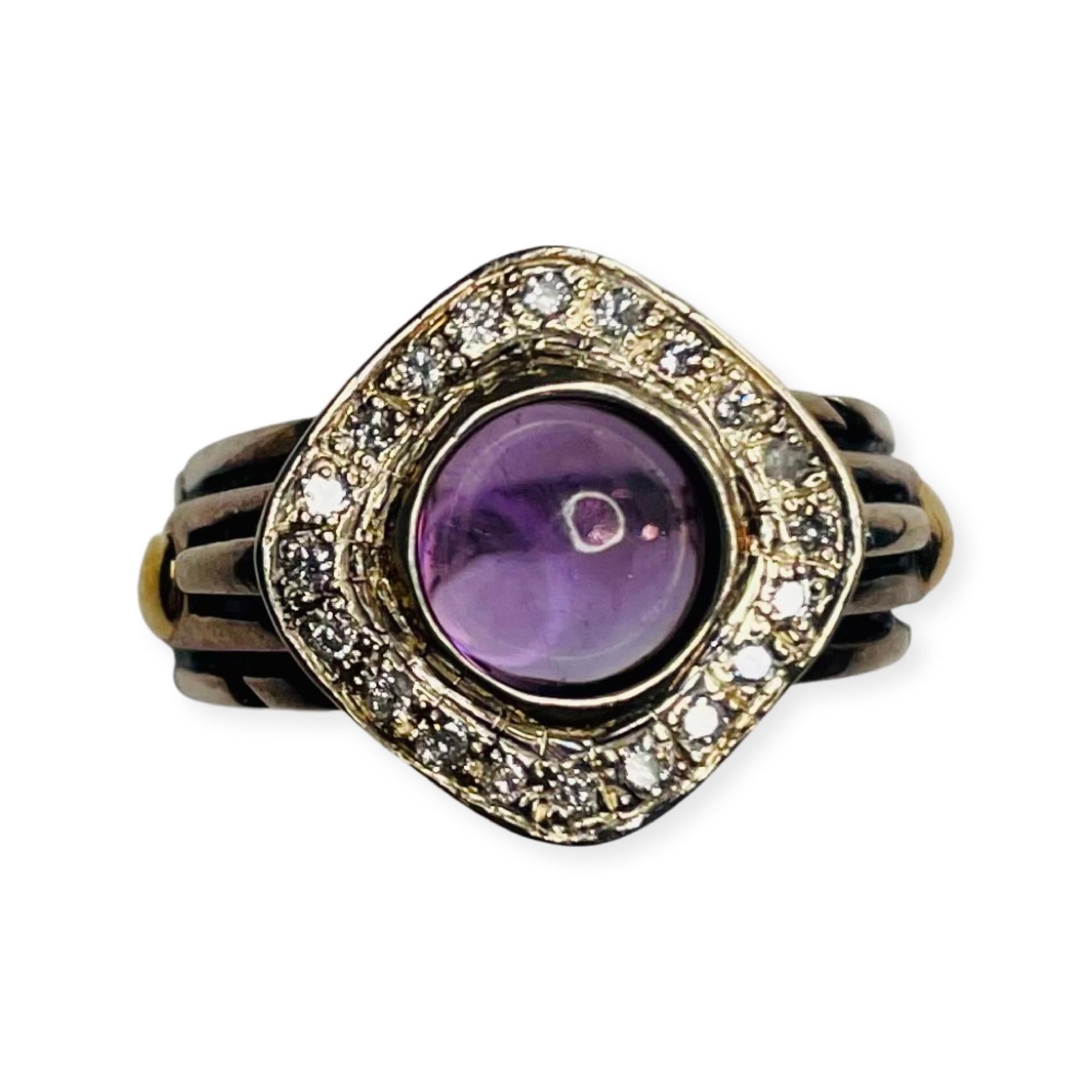 Amethyst And Diamond John Atencio Ring.  The ring is 18K yellow gold and sterling silver. The amethyst is bezel set and a round cabochon shape. There are 20 full cut round brilliant diamonds, prong set, for a total diamond weight of 0.20 carats. The