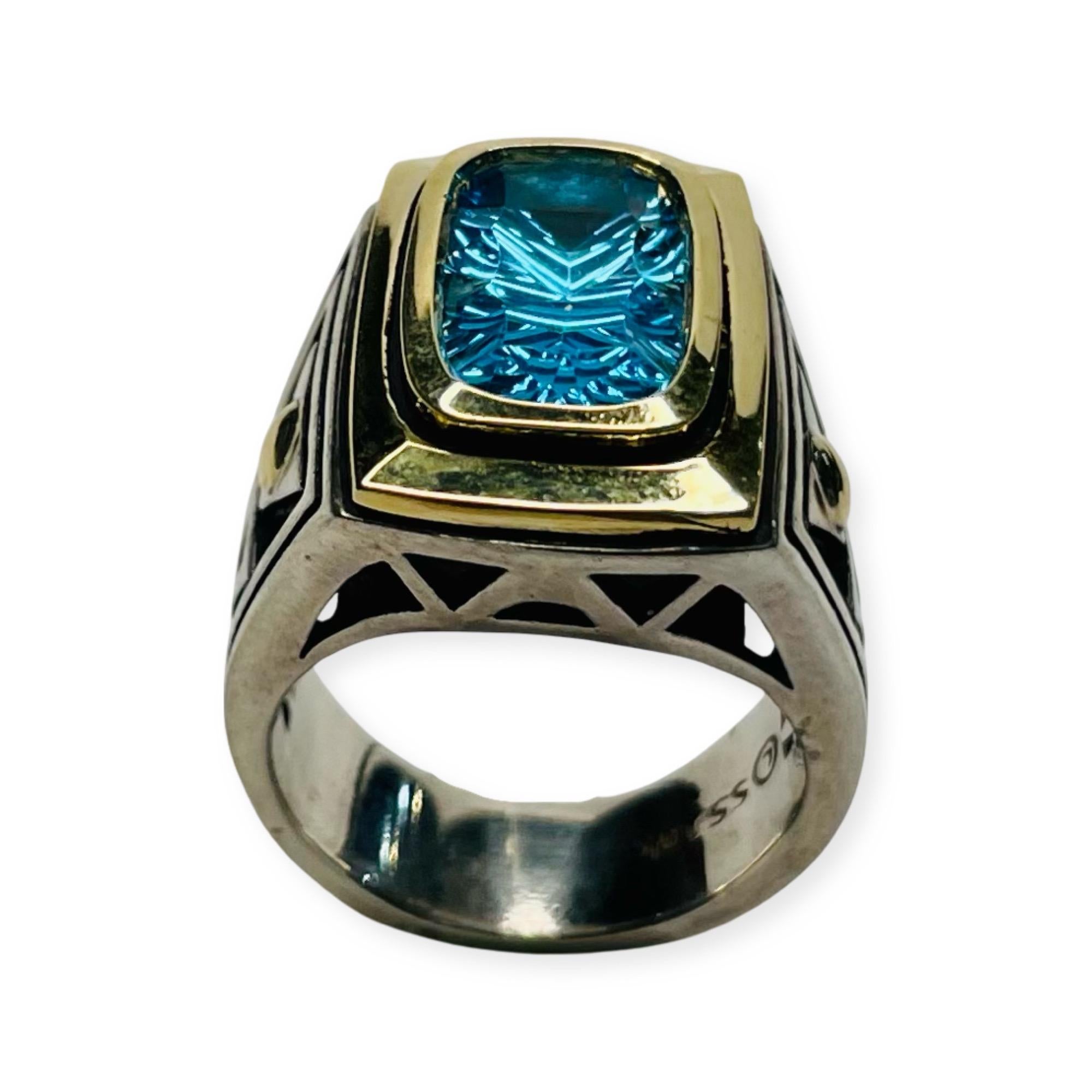 This ring is called “The Golden Gate Vertical Ring” by John Atencio.  It is 18KY gold and Sterling Silver.  There is a Faceted Blue Topaz measuring 17.0 mm x 15.0 mm.  It is bezel set on the vertical in 18KY gold. The Hallmark is 18K and 925. The