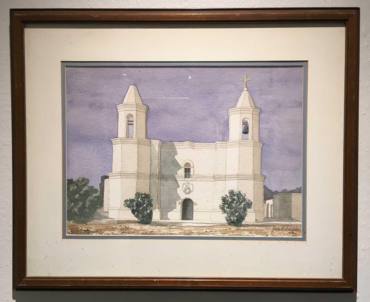 John B. Aragon's Watercolor Painting on Paper of the exterior of a New Mexico Mission Church measures 10-1/2 x 14-1/2 inches. The matting and framing bring the total dimensions to 17-5/8 x 21-5/8 x 3/4 inches. The watercolor rendering of a mission