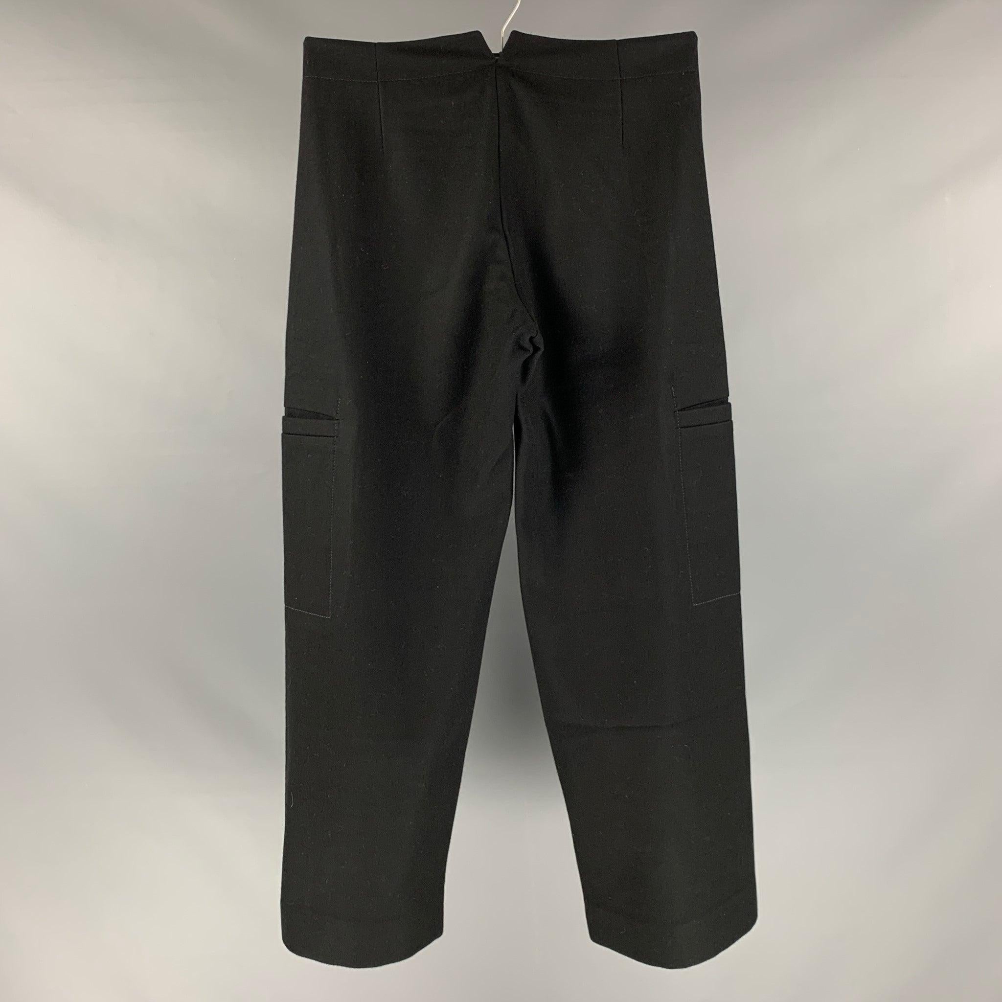 JOHN BARTLETT casual cargo pants comes in a black wool blend woven material featuring a velcro bib,
 side pockets,
 and zipper fly closure.Excellent Pre-Owned Condition. 

Marked:   48 

Measurements: 
  Waist: 32 inches  Rise: 10.5 inches  Inseam: