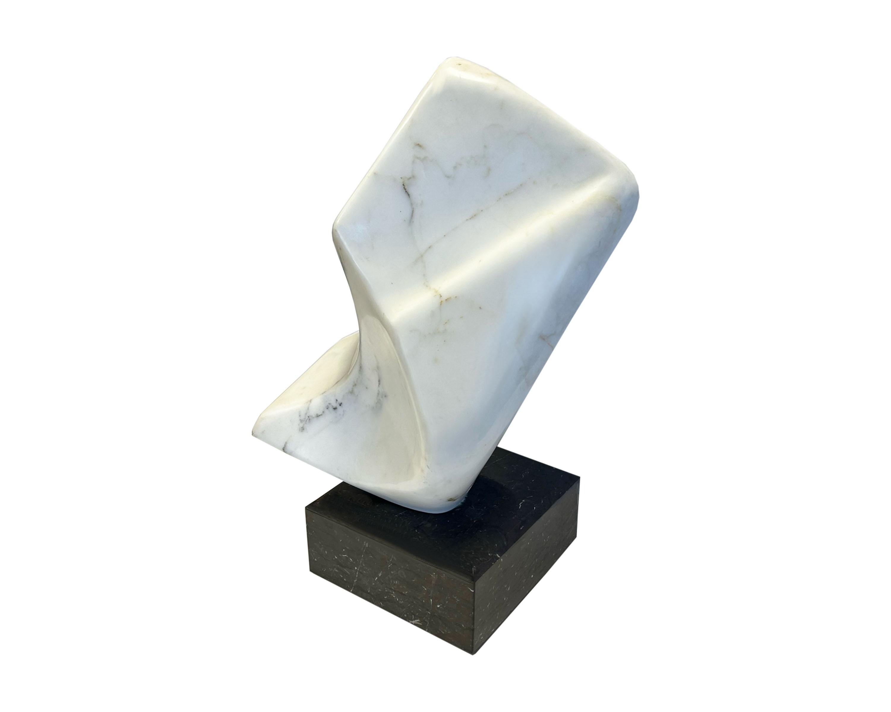 A 1990 stone sculpture by the American artist John Bartolomeo (1923-2012). Carved from solid marble, this abstract work uses white marble veined with black and tan to create a biomorphic form. Attached to a solid black marble base, the sculpture is
