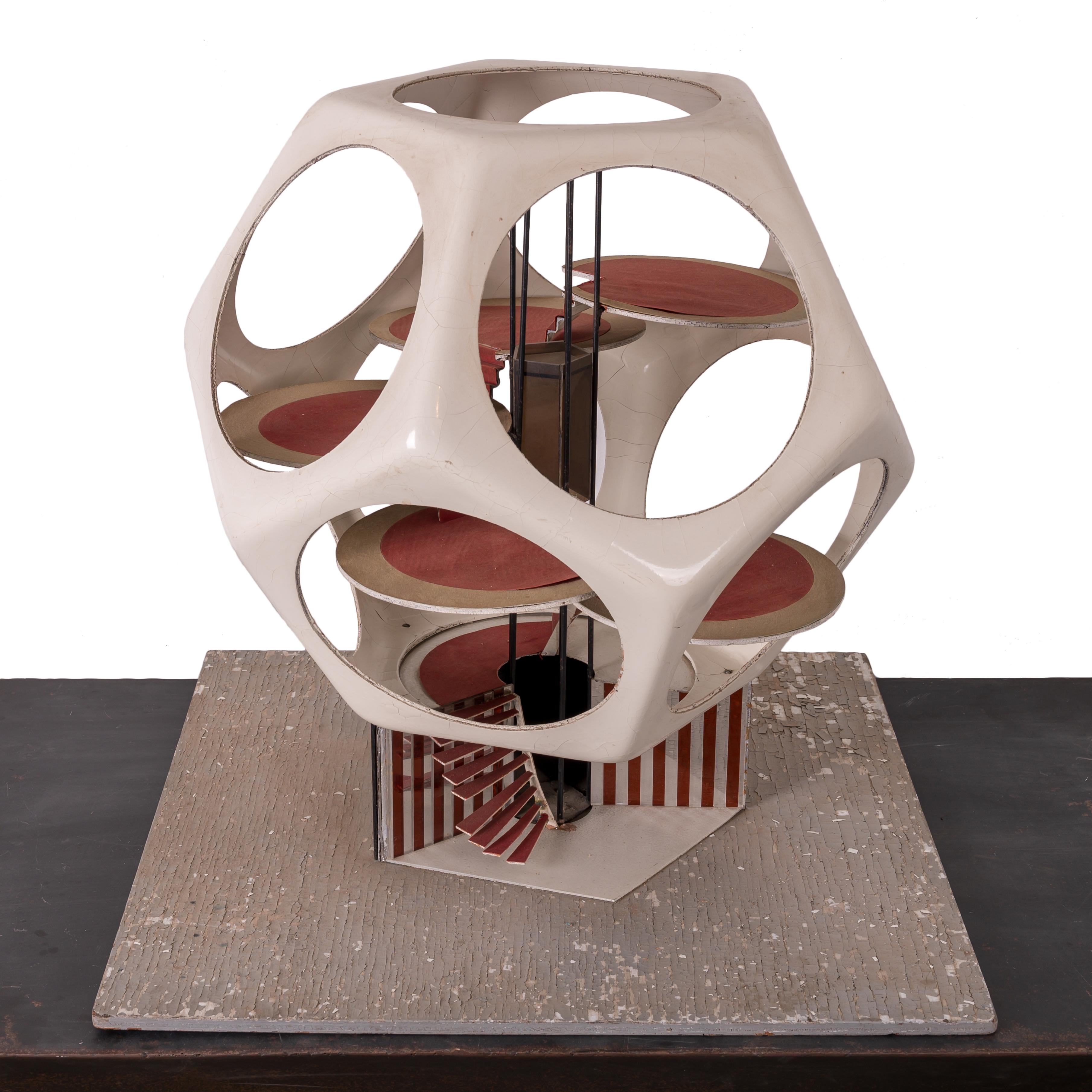 Giovanni 'John' Bucci
(Italo-Amerikaner, 1935-2019)

Ein futuristisches Dodekaeder-Hausmodell.  
Glasfaser, Acryl, Stahl und verschiedene Medien

Das Haus ist 25 Zoll breit und tief und 25 Zoll hoch.
Montiert auf einem Brett, das 27 Zoll im Quadrat