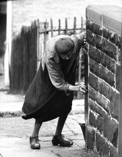 Signora che pulisce il palo del cancello, Nelson, 1960 - John Bulmer (Fotografia)