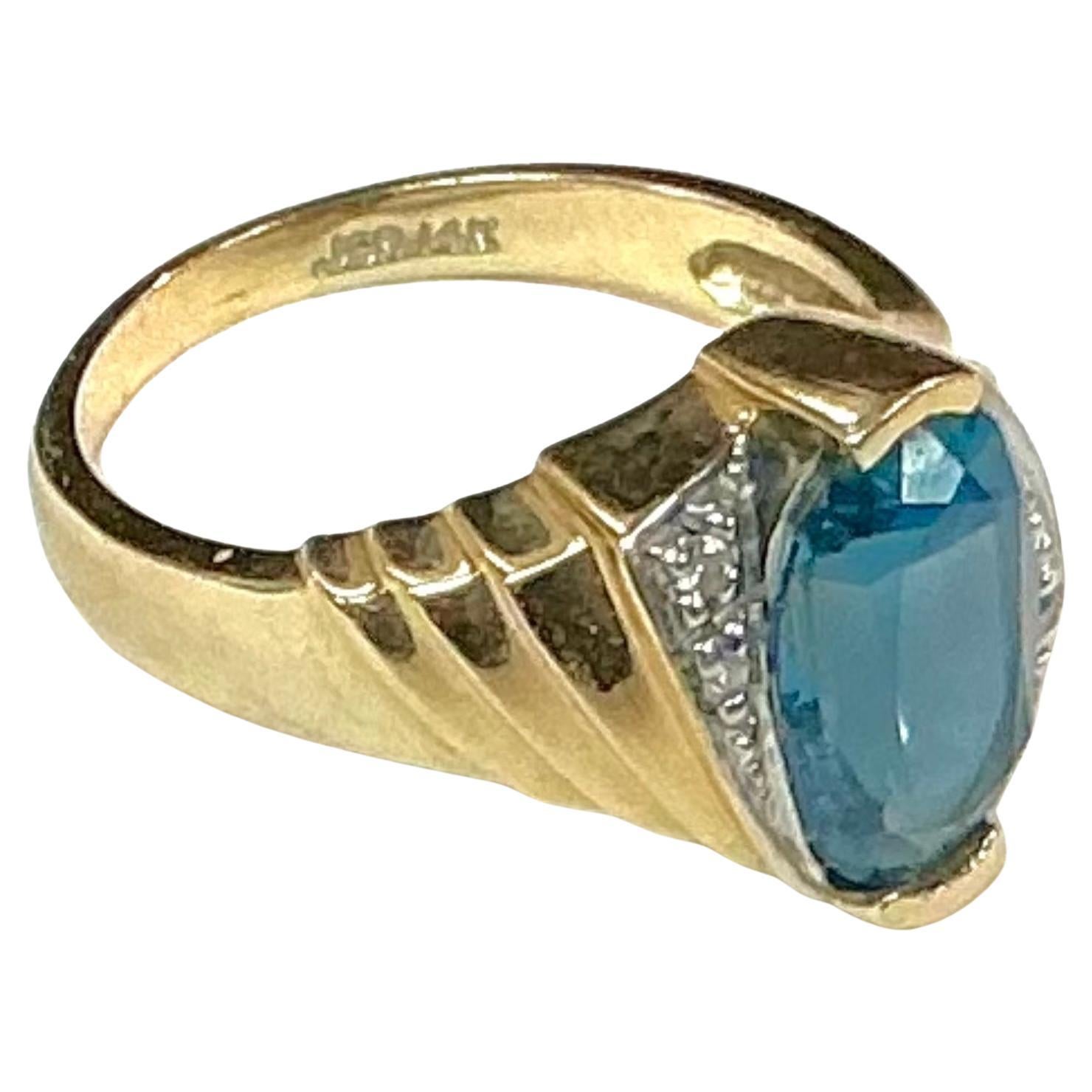 14k yellow gold blue topaz and diamond ring, 4.87 Grams TW. The dimensions of the oval aquamarine are approximately 11.5 mm x 7.5 mm. Approximately 3 carats. Marked 14k. Approximate size 7. Marked JCR for John C Rinker.