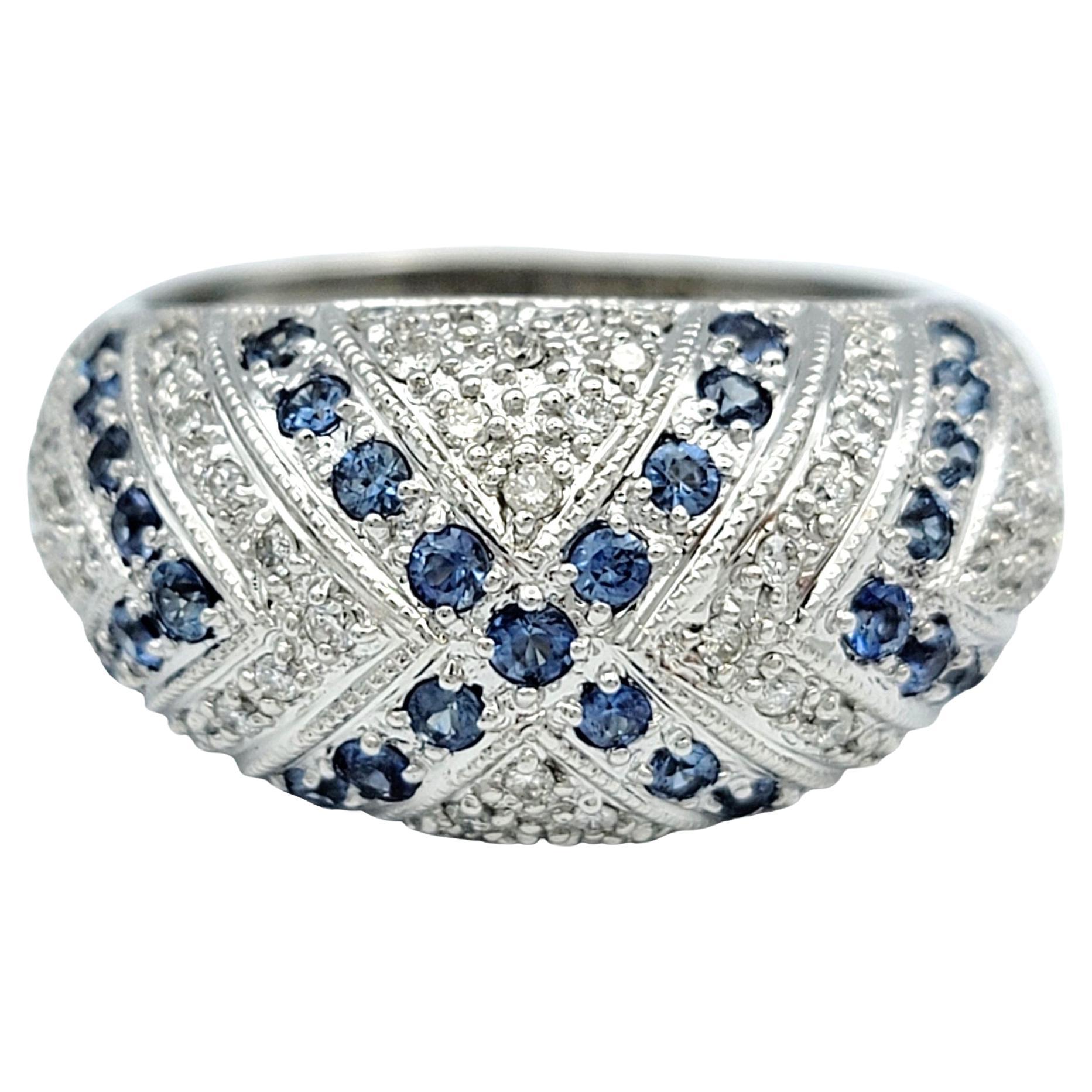 Ring size: 9.25

Exquisite elegance meets timeless design with this stunning John C. Rinker domed band ring. This polished masterpiece showcases an alternating pattern of brilliant round diamonds and captivating blue sapphires, each meticulously set