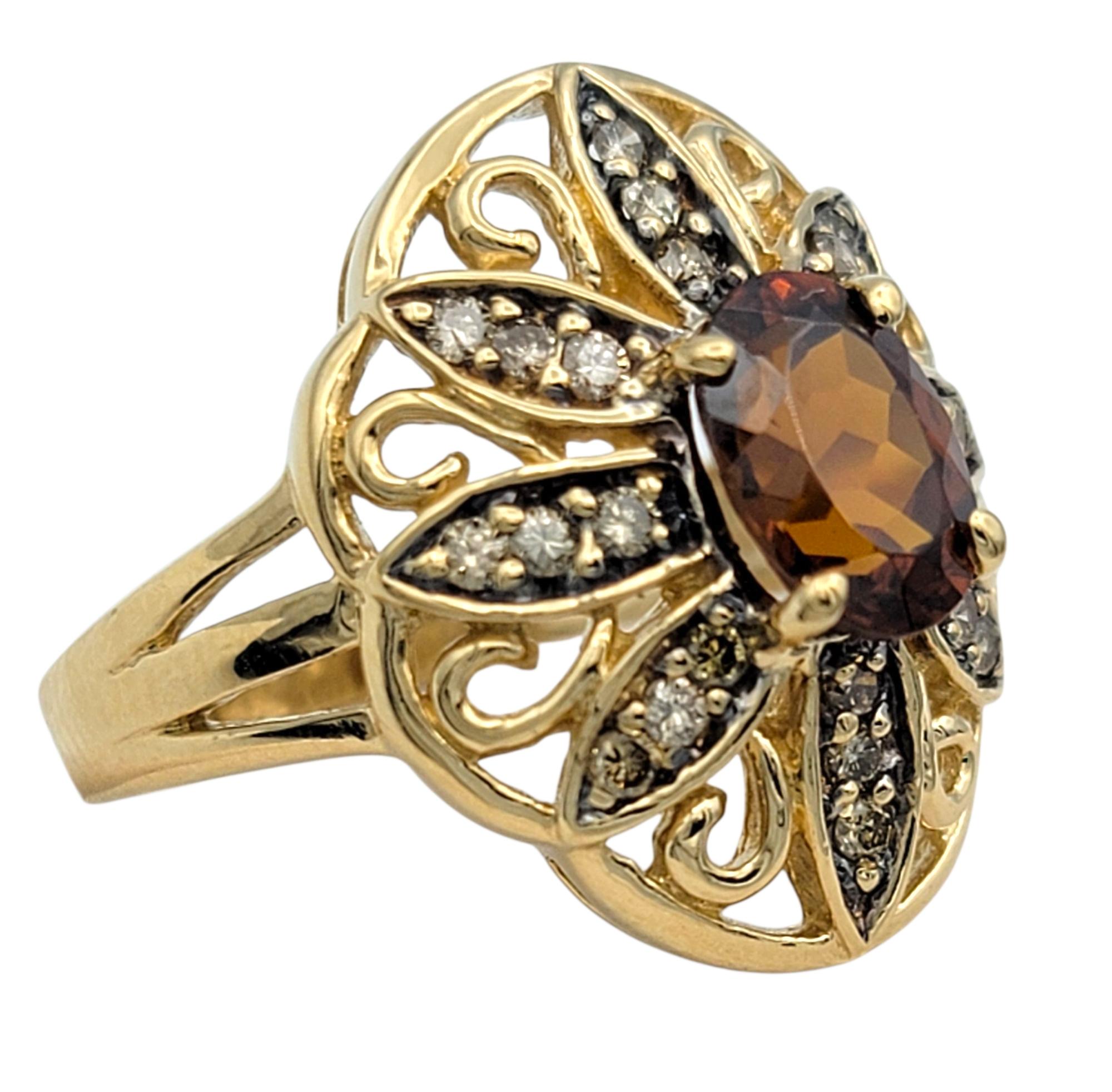 Ring Size: 6

This bold vintage-style ring from John C. Rinker features a vivid oval cut red zircon at the center, framed by an intricate openwork design of glittering round diamonds. The lacy metalwork in warm 14 karat yellow gold creates a