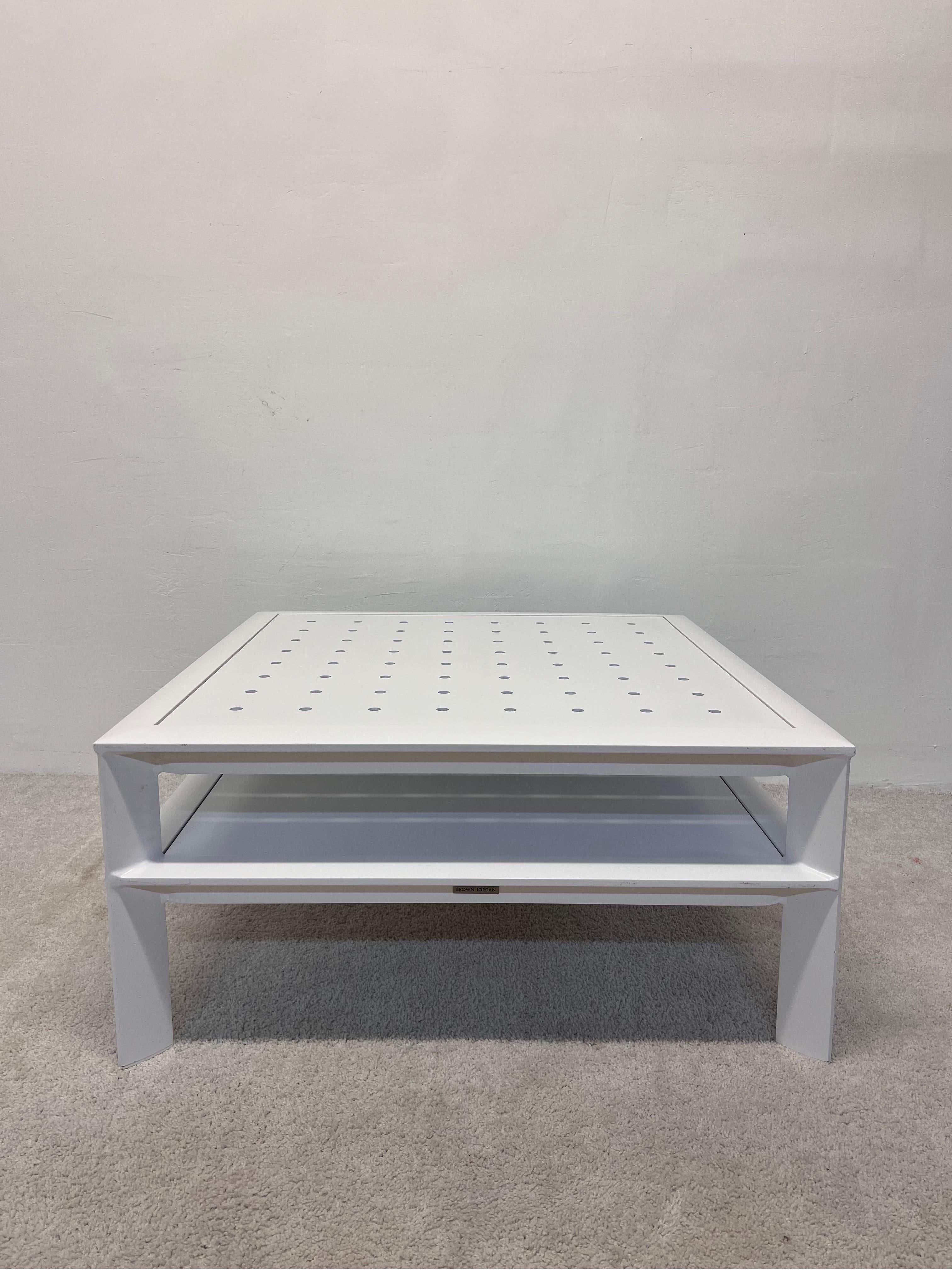 White powder-coated aluminum outdoor coffee or cocktail table with perforated top and lower shelf by John Caldwell for Brown Jordan.

We have two tables available.  Please see our other listings for second table and contact if a combined shipping