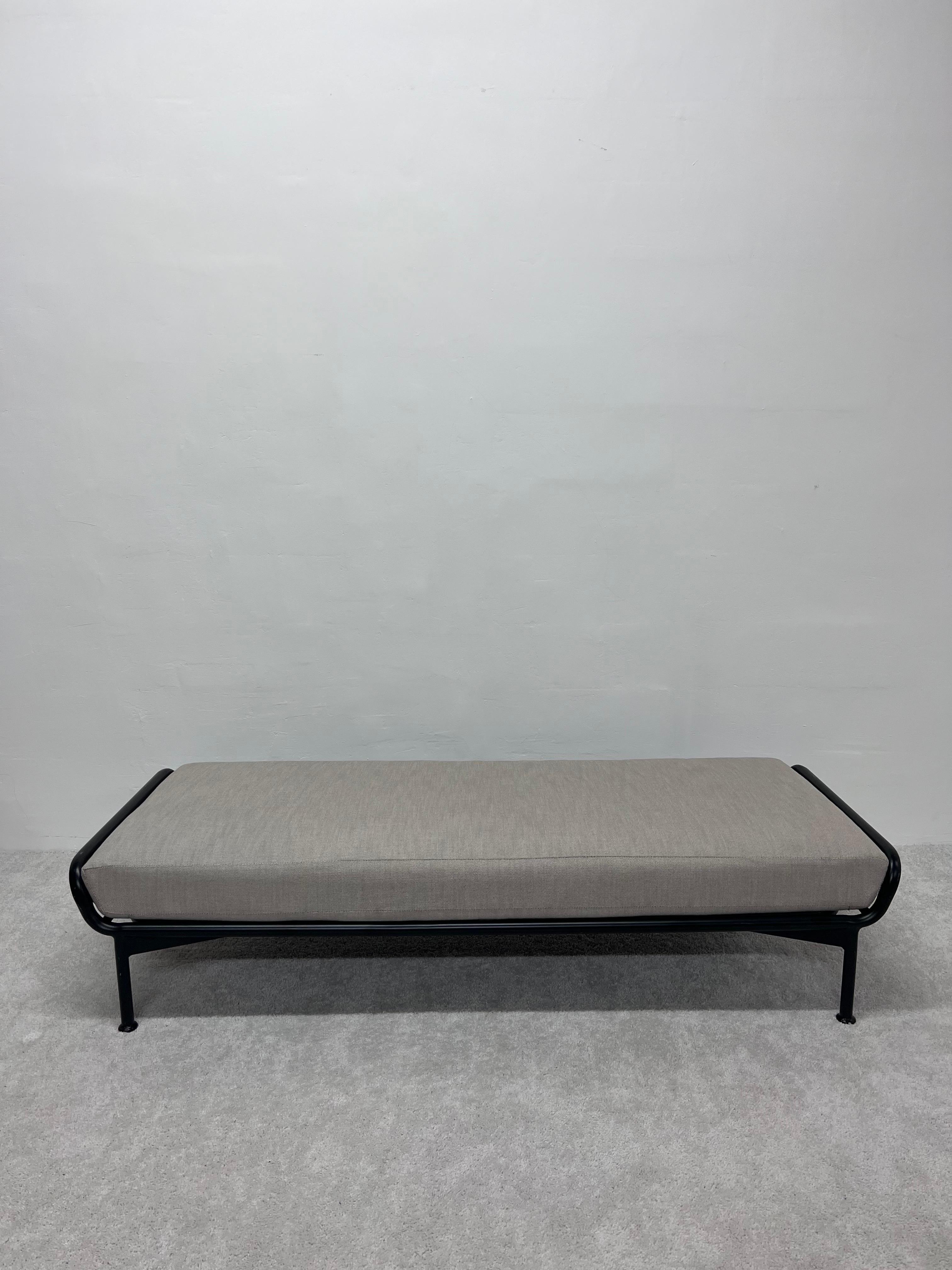 Black lacquered aluminum frame daybed or bench with light gray outdoor cushion and sun cloth straps designed by John Caldwell for Brown Jordan.