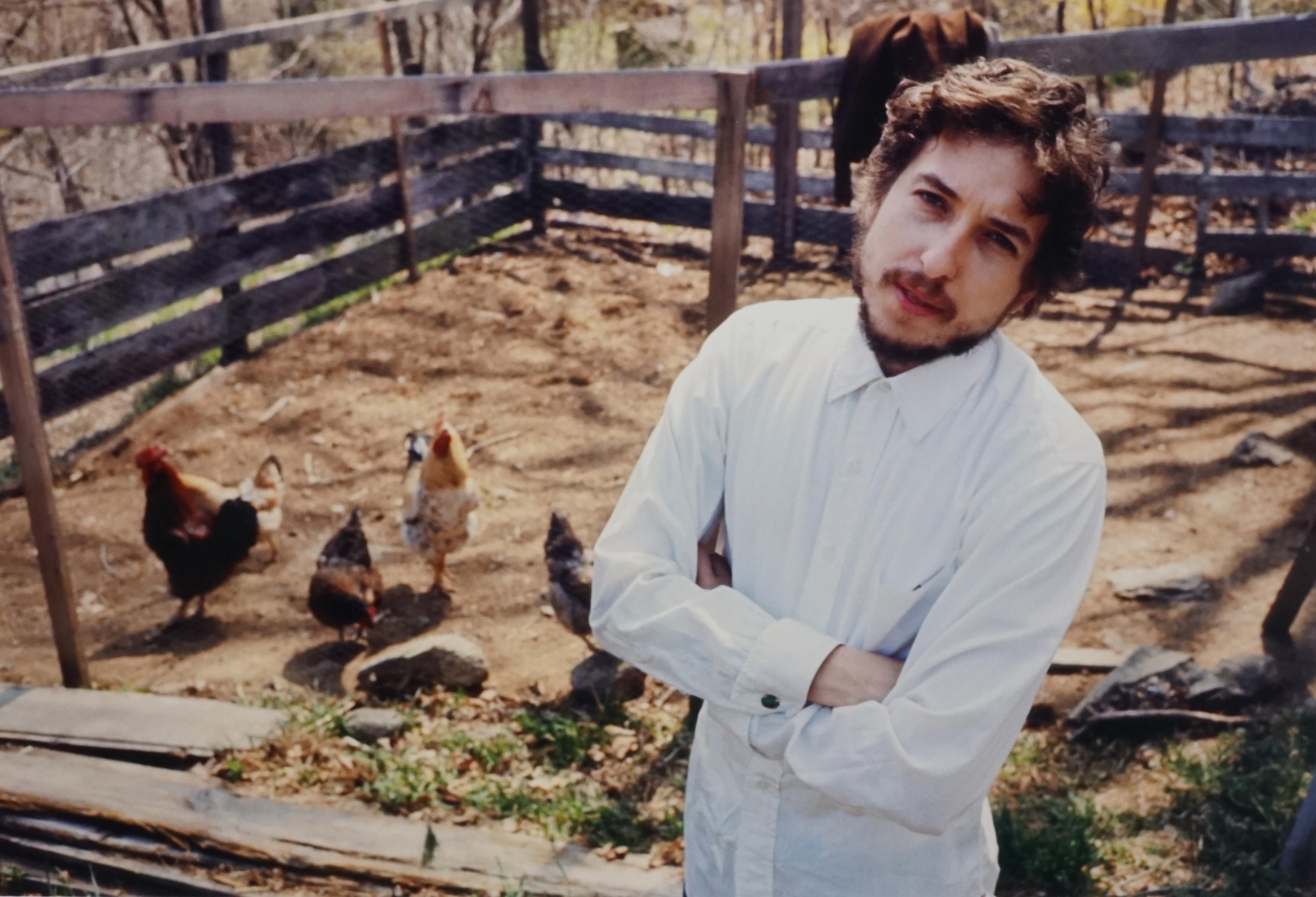 John Cohen Color Photograph - Bob Dylan in Putnam Valley (in chicken yard with arms crossed), 1970 