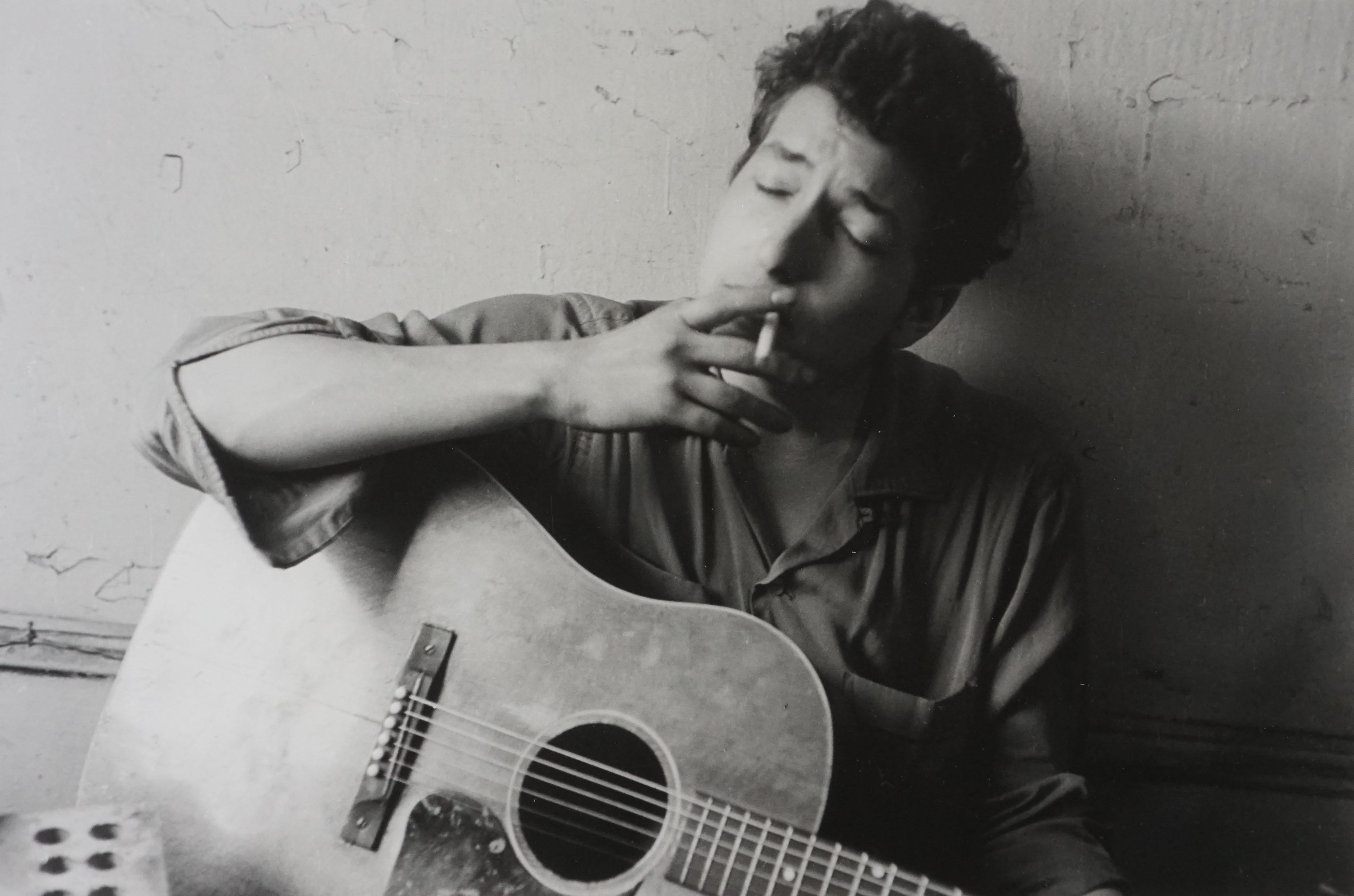 John Cohen Black and White Photograph - Bob Dylan, New York [holding cigarette & guitar], 1962/Printed 2005