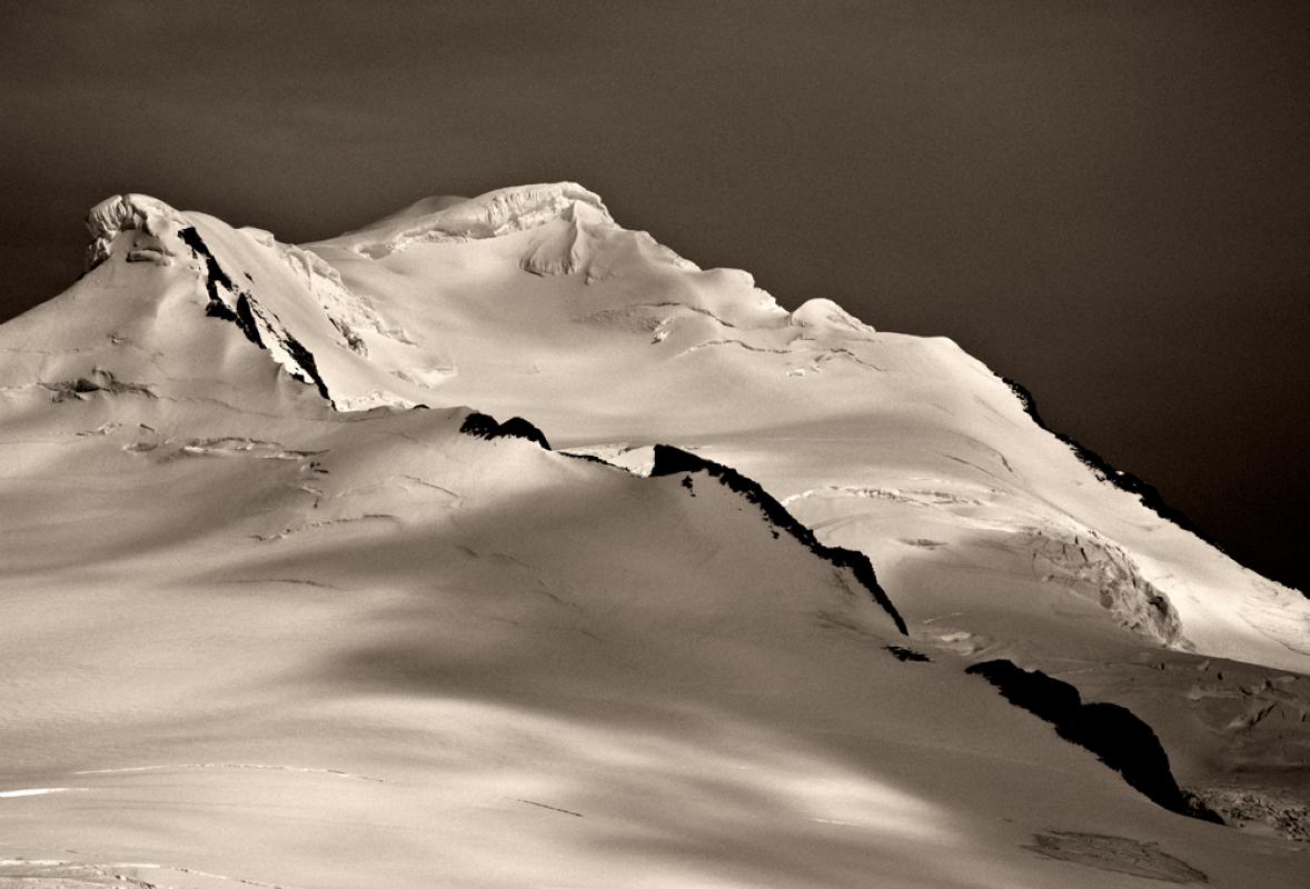 Antarctica #4 small is a Black and White limited edition photograph taken by John Conn in 2010.  It is a 13x19 image, printed on 16x22 archival paper.  It features a snow covered mountain.   It is signed and numbered.  It is an edition of 10.  It is