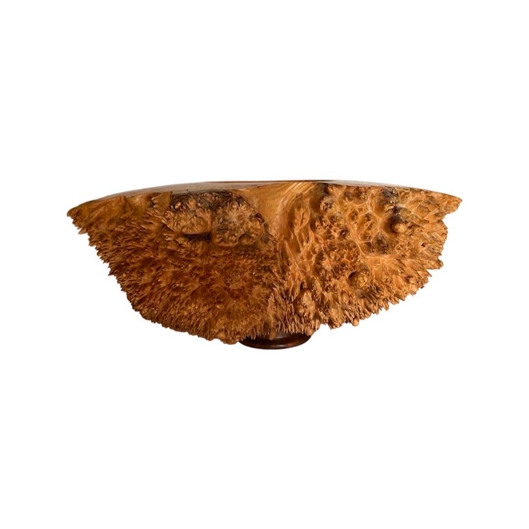 A fantastic live edge organic sculpture constructed from a solid piece of maple burl wood. Modern style with a heavy weight, spikes to side and recessed bowl to center. Signed to bottom 1997.

Biography: 

John Dickinson was born and raised in
