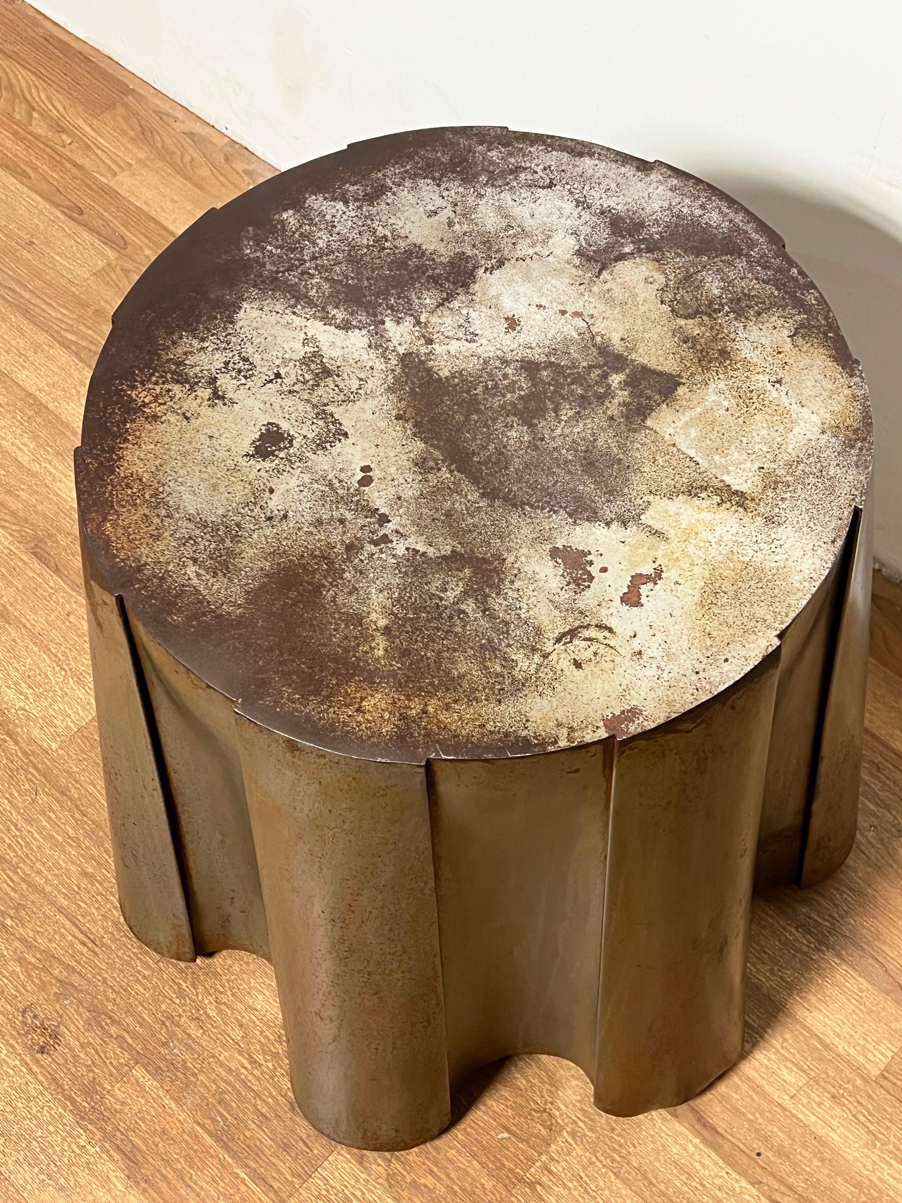 A postmodern side table in galvanized and oxidized steel, fashioned to look as if the table is draped in fabric, in the style of John Dickinson.


