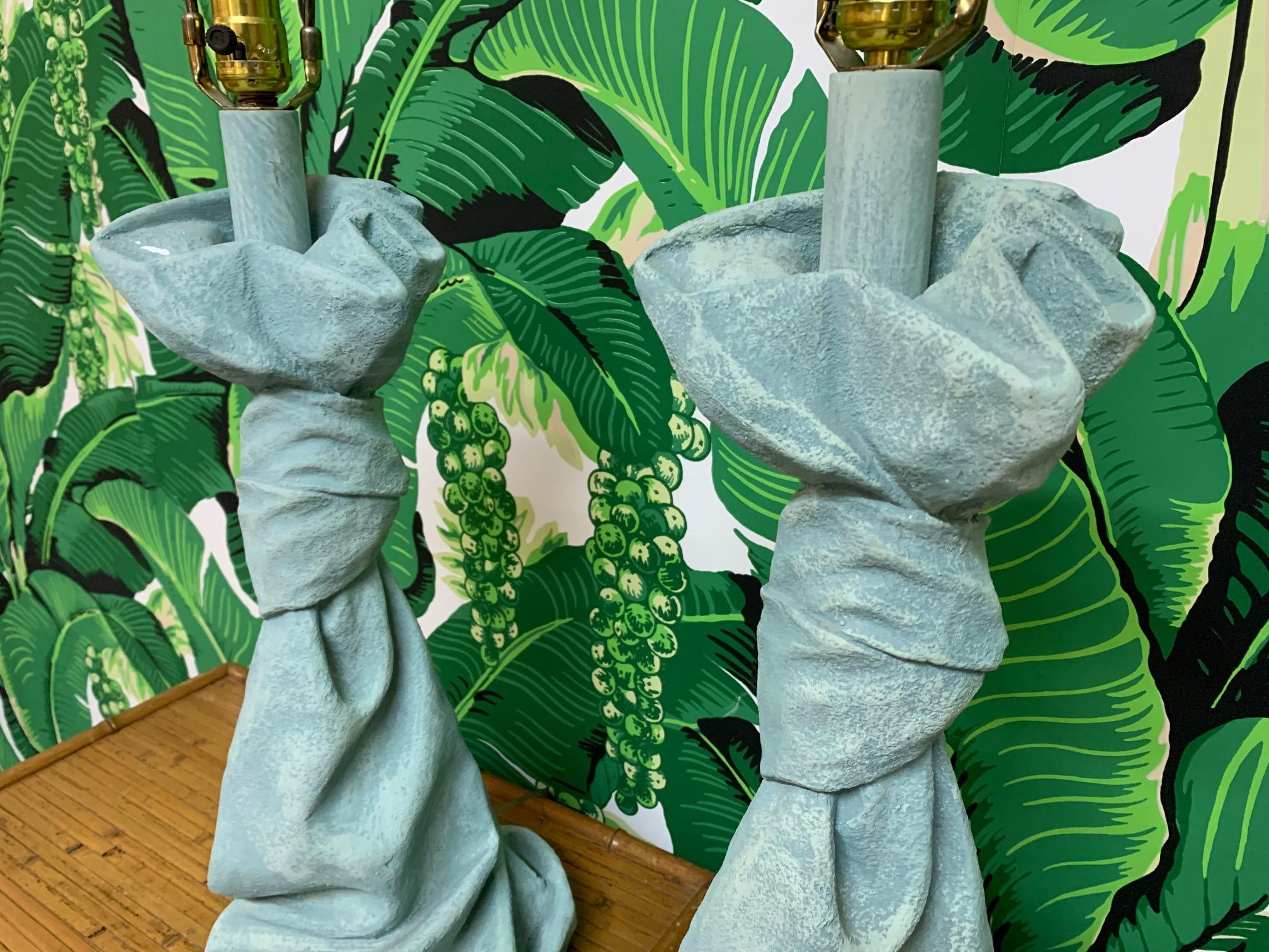 Pair of table lamps in draped fabric motif in the style of John Dickinson. Heavy plaster construction. Good vintage condition with minor imperfections consistent with age.