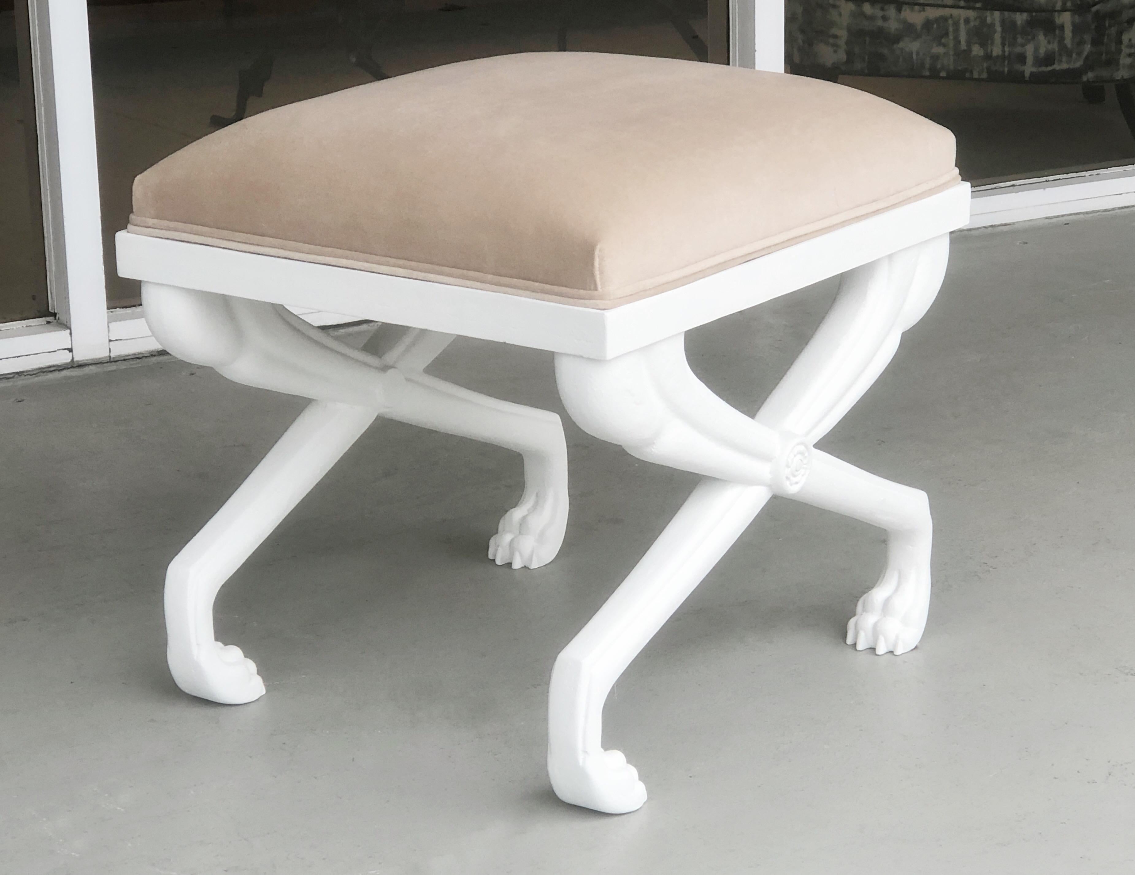 A solid cast metal bench or stool with a white finish. Upholstered seat. Nice detail and striking design.