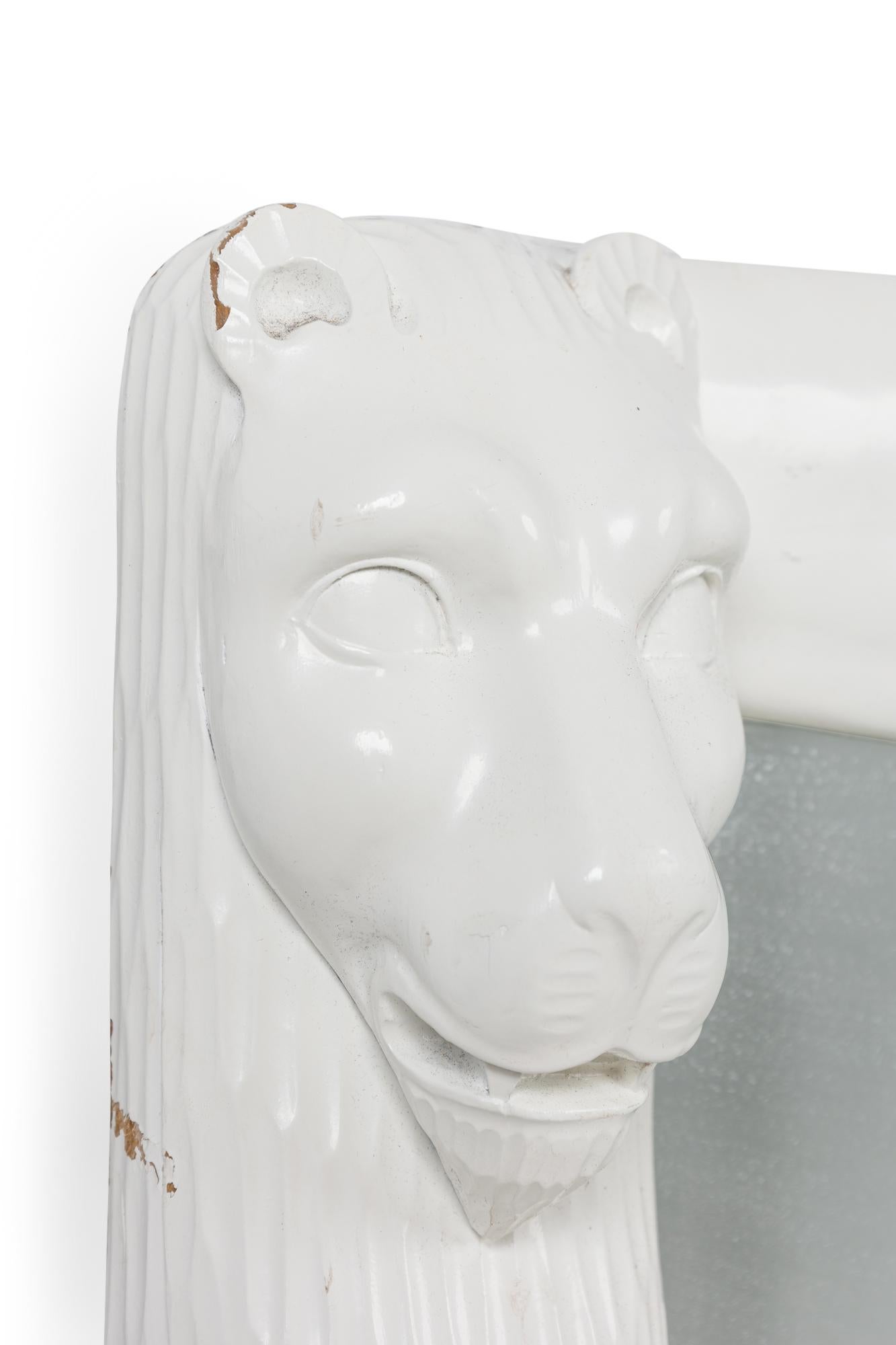Miroir rectangulaire vertical en laque blanche de style américain du milieu du siècle, avec des masques à tête de lion dans les coins supérieurs (style JOHN DICKINSON).