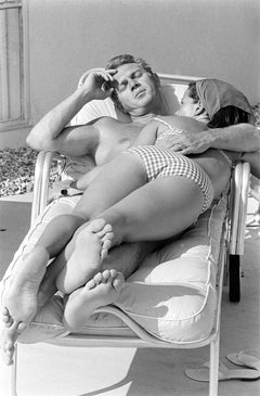 Steve McQueen and his wife, Neile Adams, laying on a chair, California, 1963