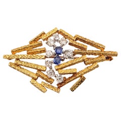 Spilla modernista JOHN DONALD 1969 in oro giallo 18Kt con diamanti e zaffiri.