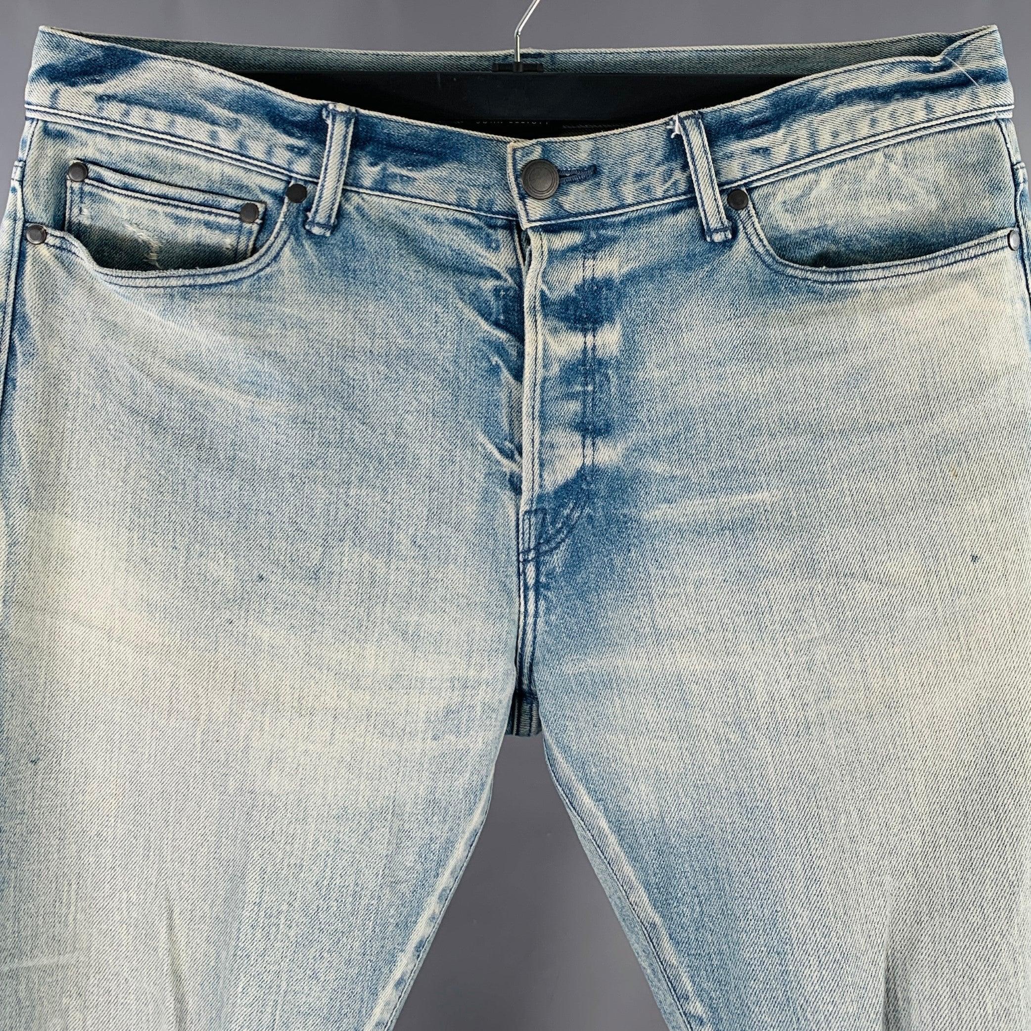 JOHN ELLIOTT jeans
in a blue cotton blend denim featuring a distressed style with visible mending details, slim fit, and button fly closure. Made in Japan.Excellent Pre-Owned Condition. 

Marked:   34 

Measurements: 
  Waist: 34 inches Rise: 9.5