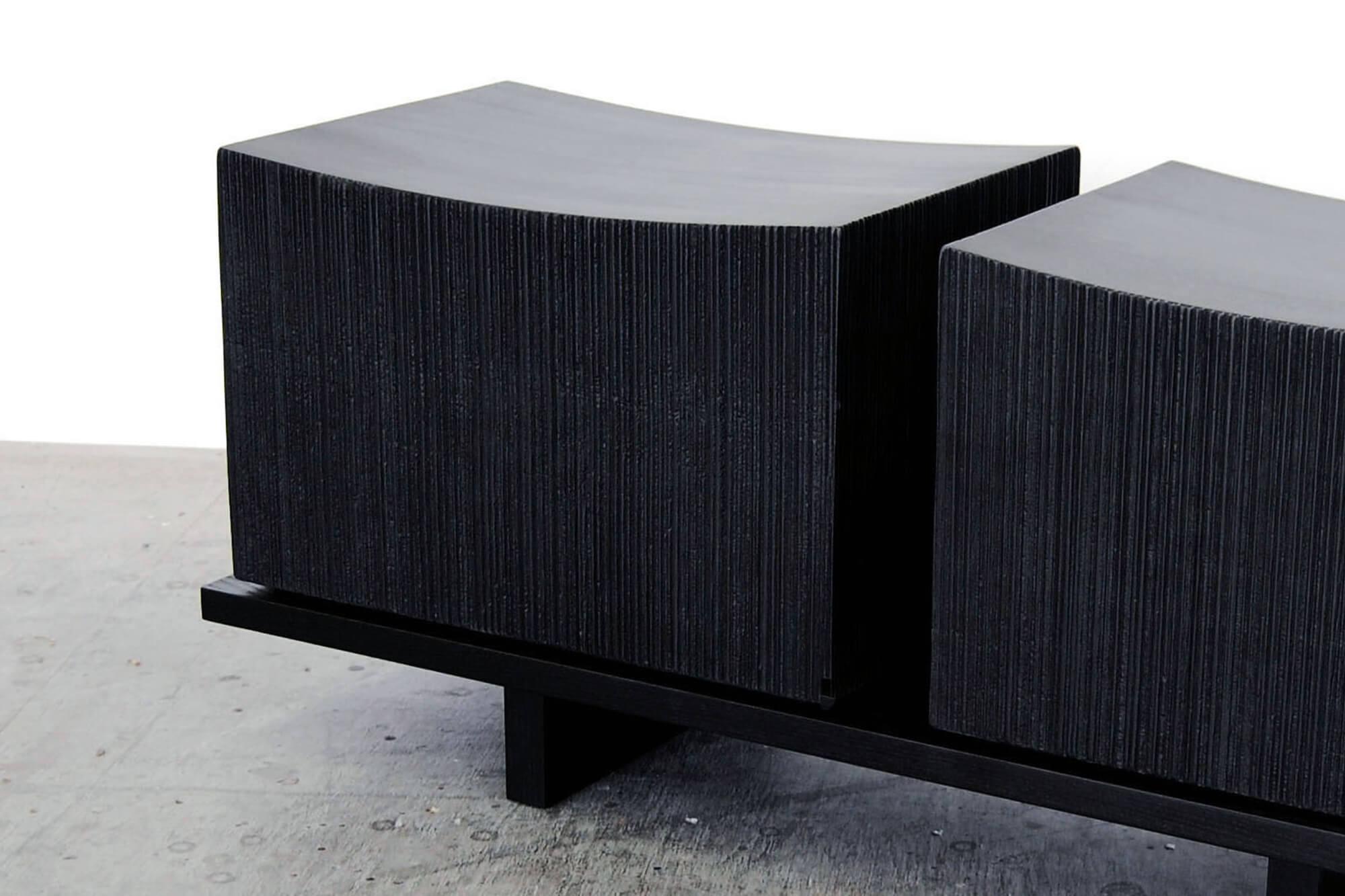 This elevated bench from John Eric Byers merges bold, modern geometries with traditional craft. The wood is hand-sawn and lacquered with a distinctive textured pattern to give a sophisticated finish to a simplified silhouette. 

John Eric Byers is