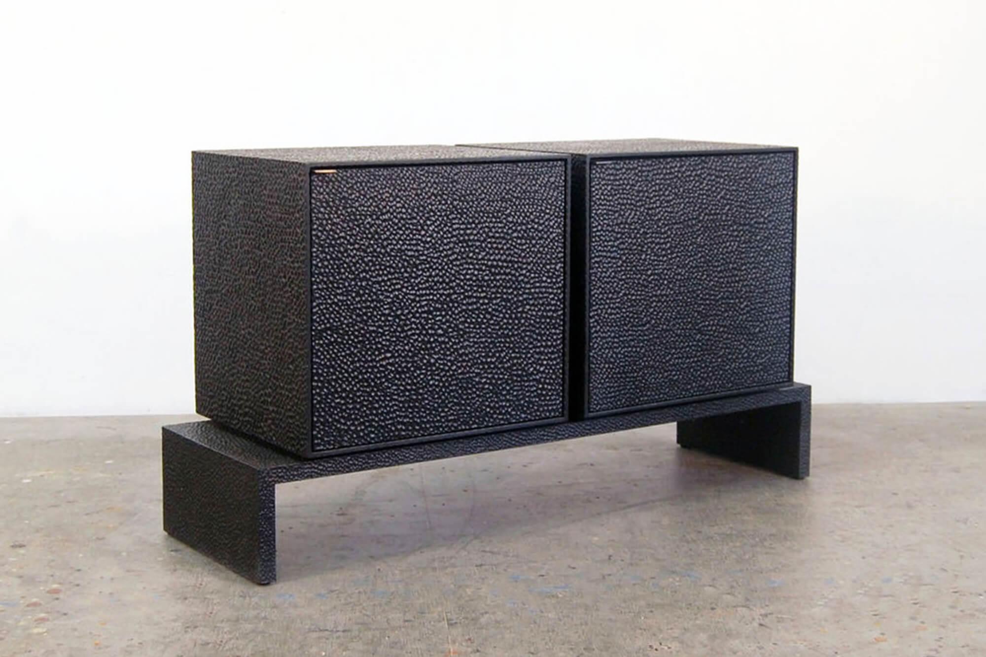 This elevated credenza from John Eric Byers merges bold, modern geometries with traditional craft. The cabinets and platform are hand-carved and lacquered with a distinctive textured pattern to give a sophisticated finish to a simplified