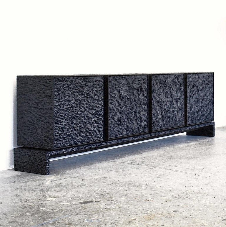 This minimalist credenza from John Eric Byers merges bold, modern geometries with traditional craft. The four cabinets and platform are hand-carved and lacquered with a distinctive textured pattern to give a sophisticated finish to a simplified