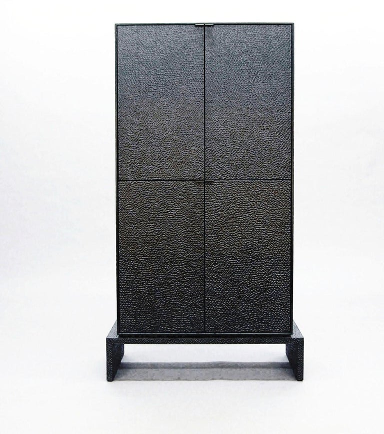 These cabinets merge bold, modern geometries with traditional craft. The wood is hand-sawn and lacquered with a distinctive textured pattern to give a sophisticated finish to a simplified silhouette.

John Eric Byers is an artist / designer /