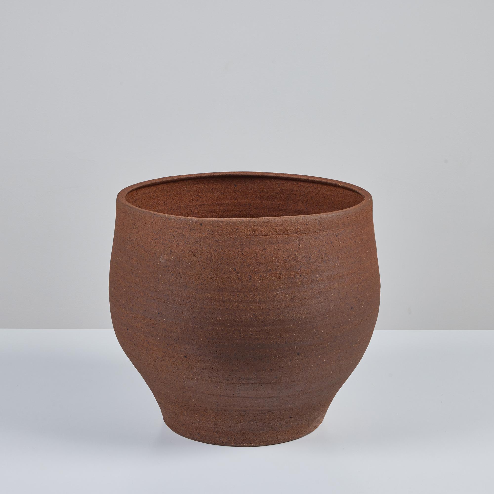 Hand Thrown stoneware planter by John Follis for Architectural Pottery, C.1960s, USA. The bell shaped planter, features the warm natural clay tones with light speckling. Our favorite detail of this planter are the finger groove created throughout