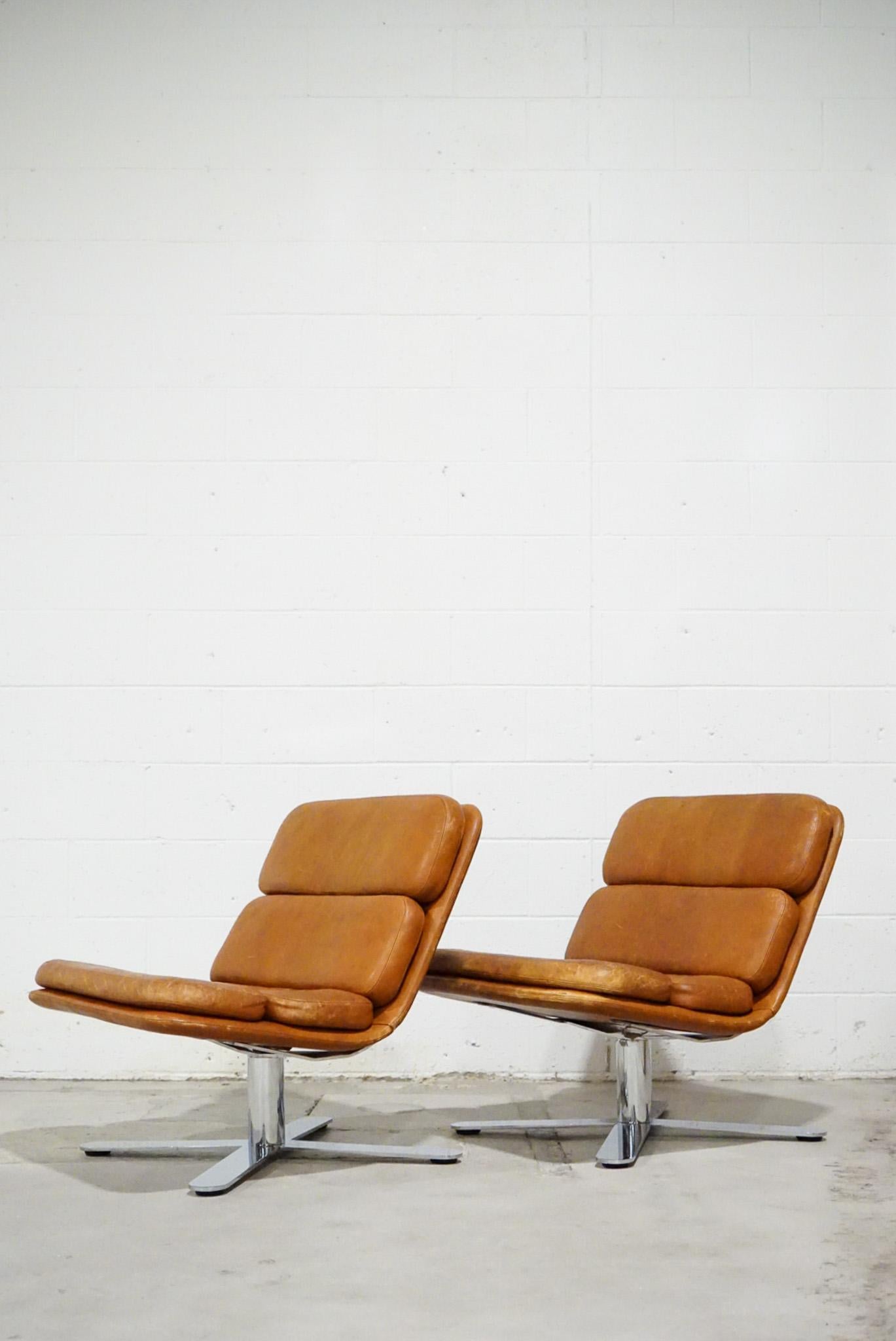 A beautiful patinated pair of vintage leather and chrome lounge chairs designed by John Follis, 1970s.
 
They are known as the 