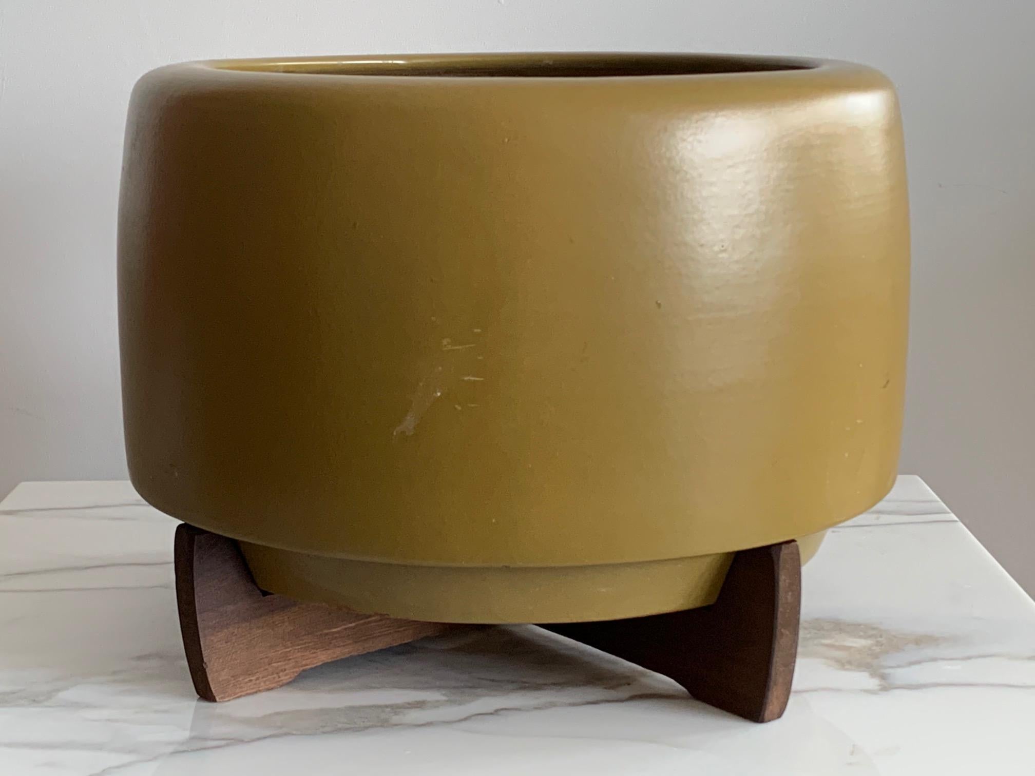 An unusual and hard to find John Follis and Rex Goode planter by Architectural Pottery circa 1970s. This is a yellow-ochre colored glaze with original redwood base. Very good original condition. Measures approximate 17.5