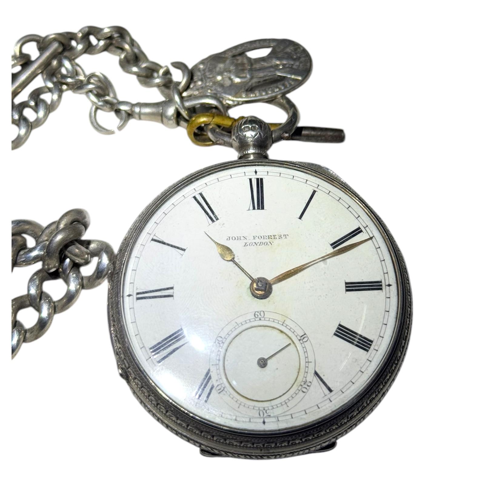 This vintage John Forrest London pocket watch was manufactured in the late 19th century in the United Kingdom. It features a mechanical (manual) movement with a fusee mechanism, a 54mm case in silver and rose gold, and a white enameled dial with a