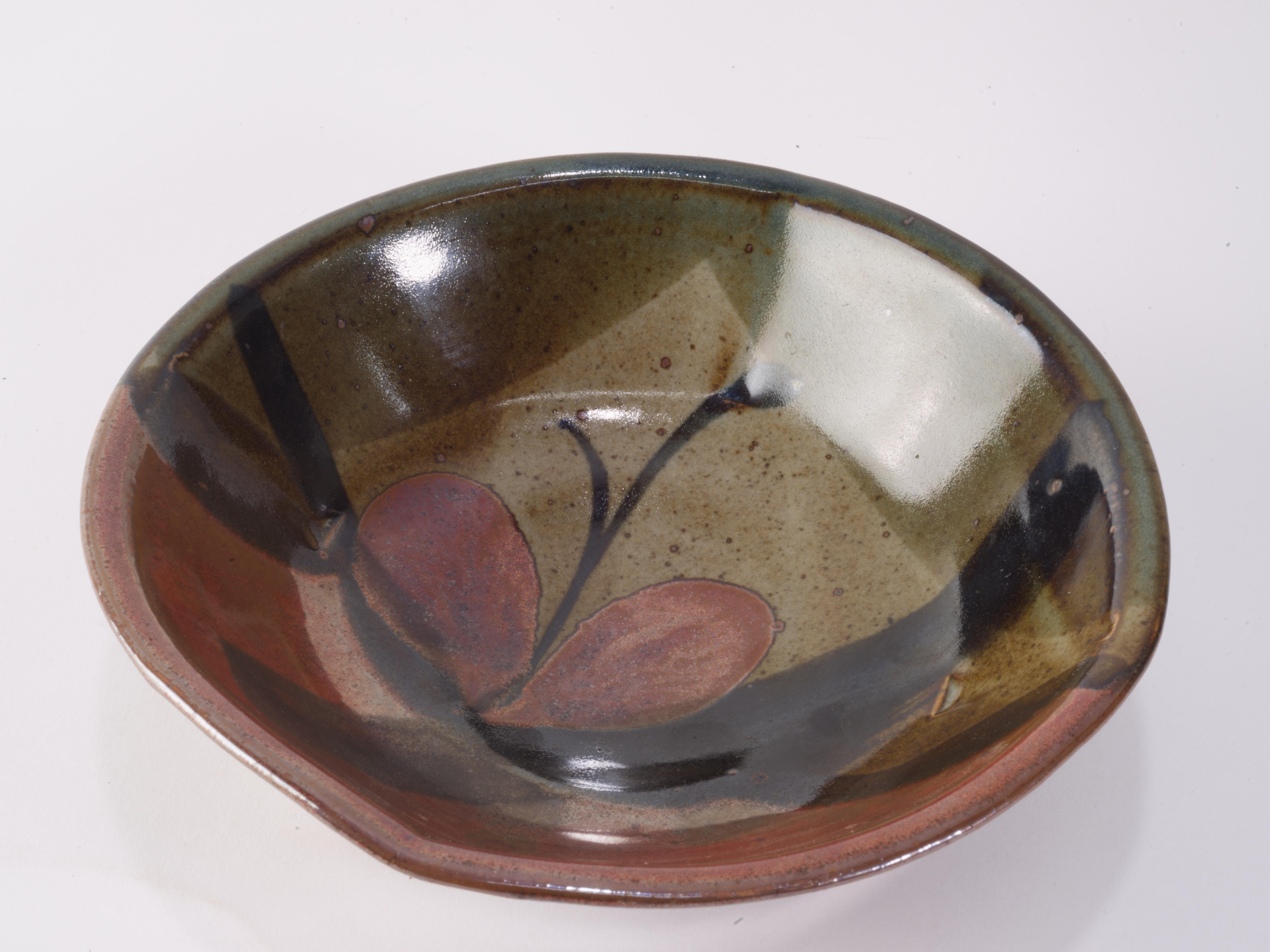  Calligraphy inspired art pottery bowl was made by John Freimarck of Freimarck Pottery as a part of a series created in late 1970s. The hand thrown bowl has a complex shape;  the circular outer rim is gently stretched in four directions, creating a