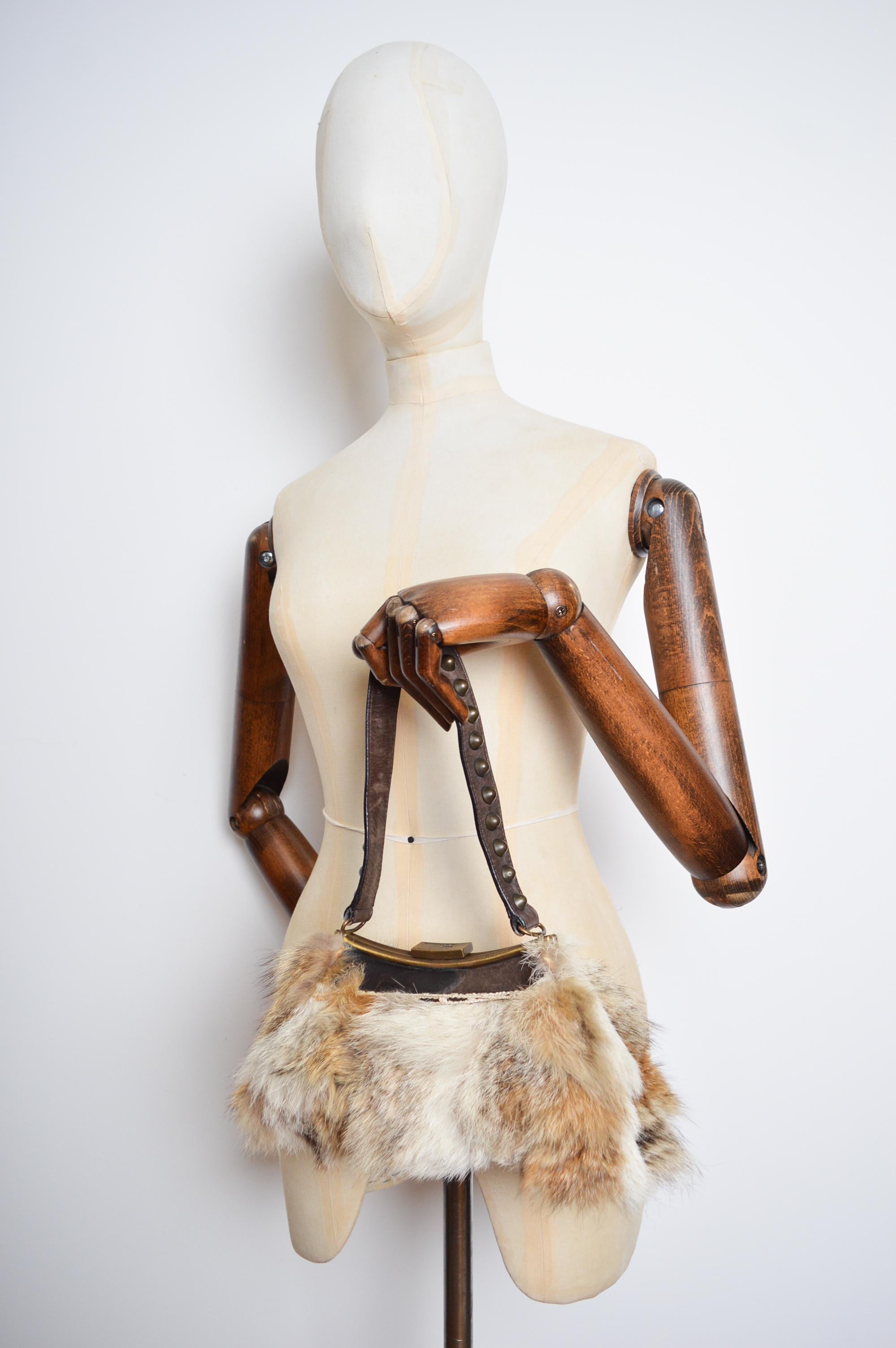 Superbe sac à bandoulière en fourrure de coyote et cuir marron par John Galliano.   

FABRIQUÉ EN ITALIE.   

Caractéristiques ; poignée supérieure en cuir, intérieur doublé en jacquard, accessoires en laiton, compartiment intérieur unique avec