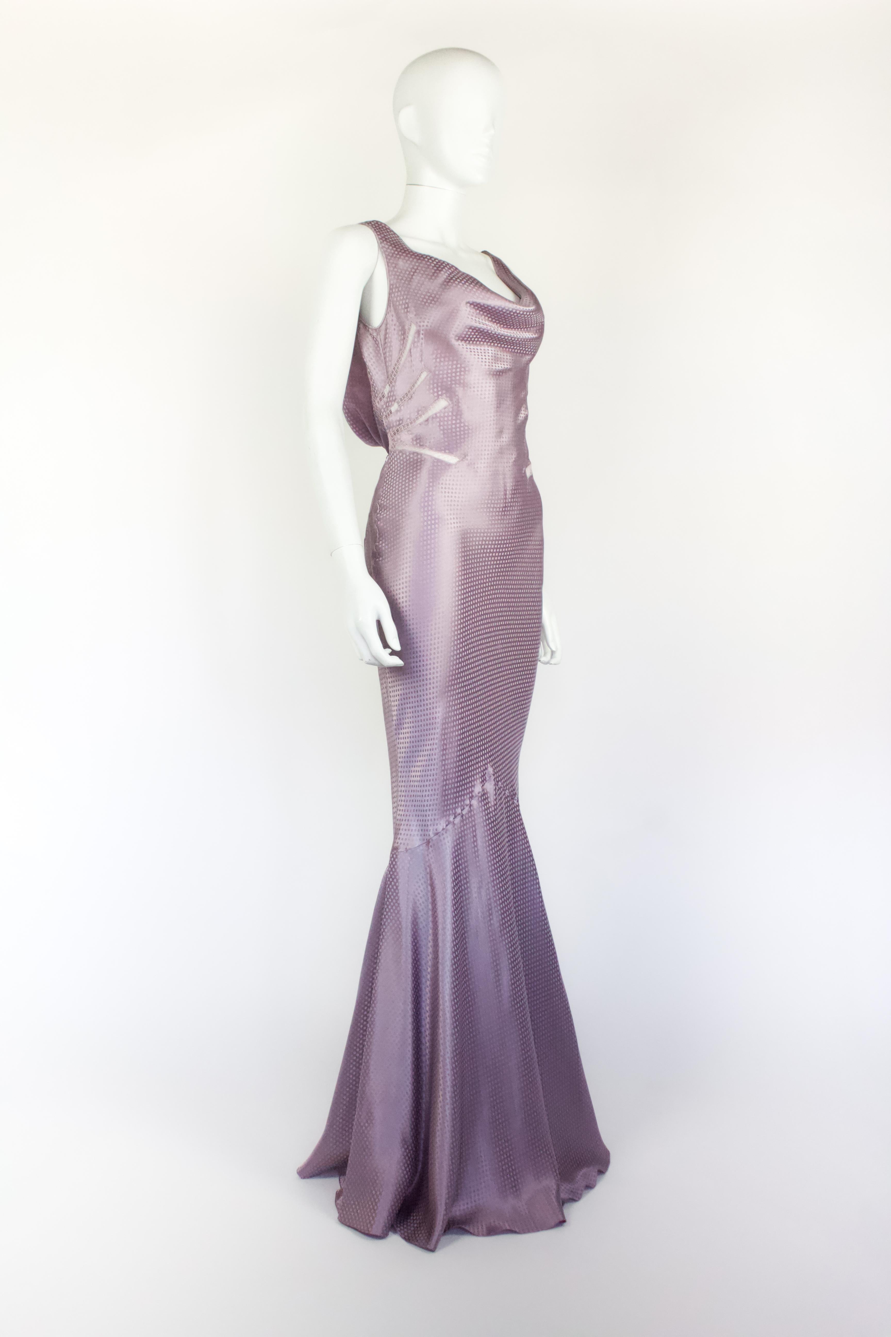 Abito in seta lilla di John Galliano, della collezione Autunno/Inverno 2004. Leggero in seta con fantasia a pois, con dettagli a cappuccio sul davanti e sul retro. Inserti in pizzo ai lati.

Condizione
Molto buono

Dimensione marcata
UK 10

Misure