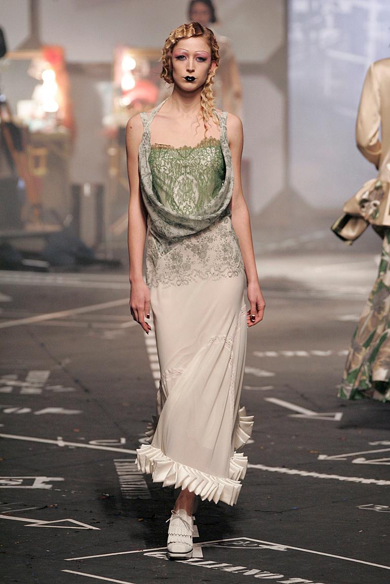 John Galliano's Fall 2005 runway silk evening dress designed with tremendous attention to detail.  Inspired with a deco flair the green lace delicate corset bodice extends into a bias cut full skirt adorned with hand folded pieces of silk at